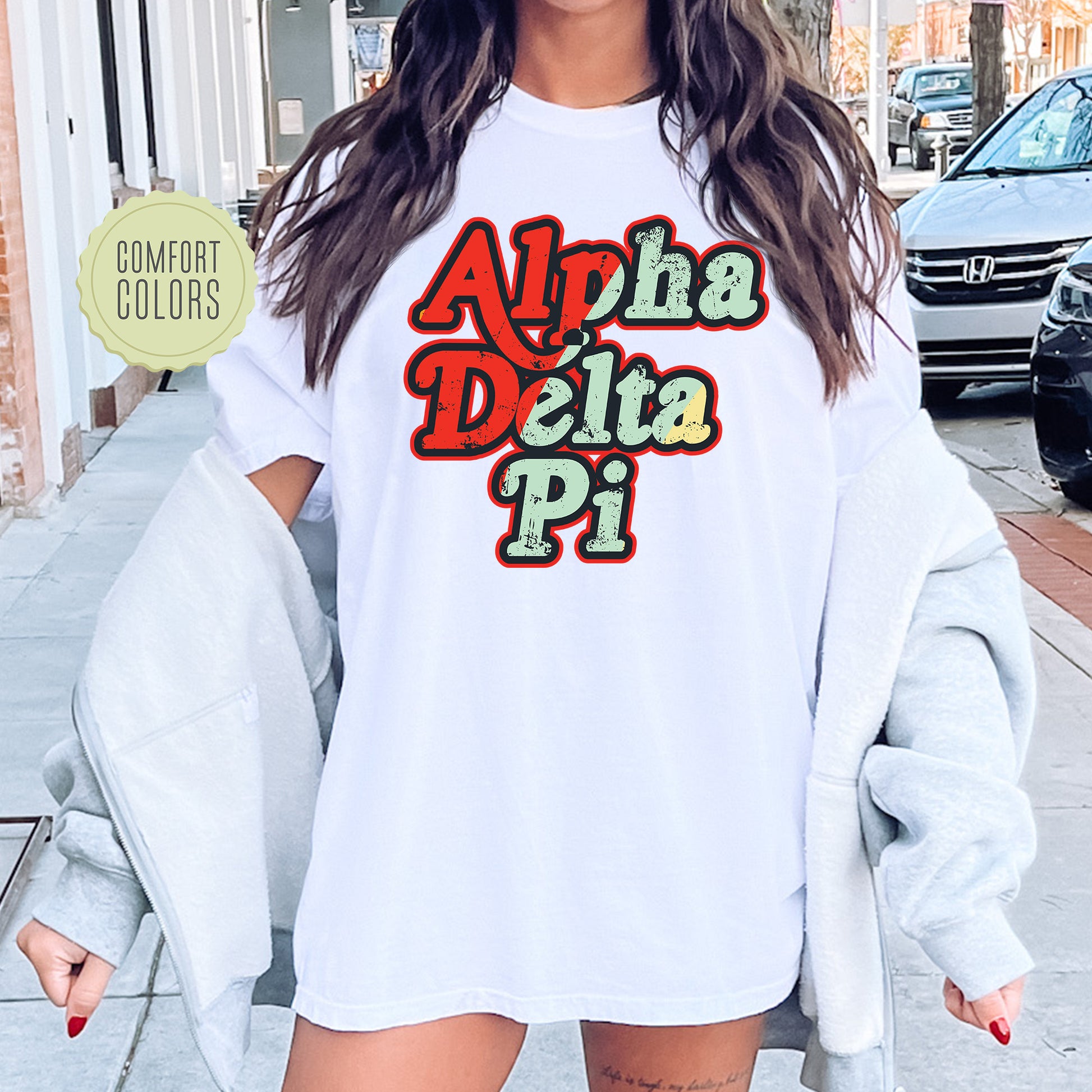 a woman wearing a white shirt with the words aloha delta pi on it