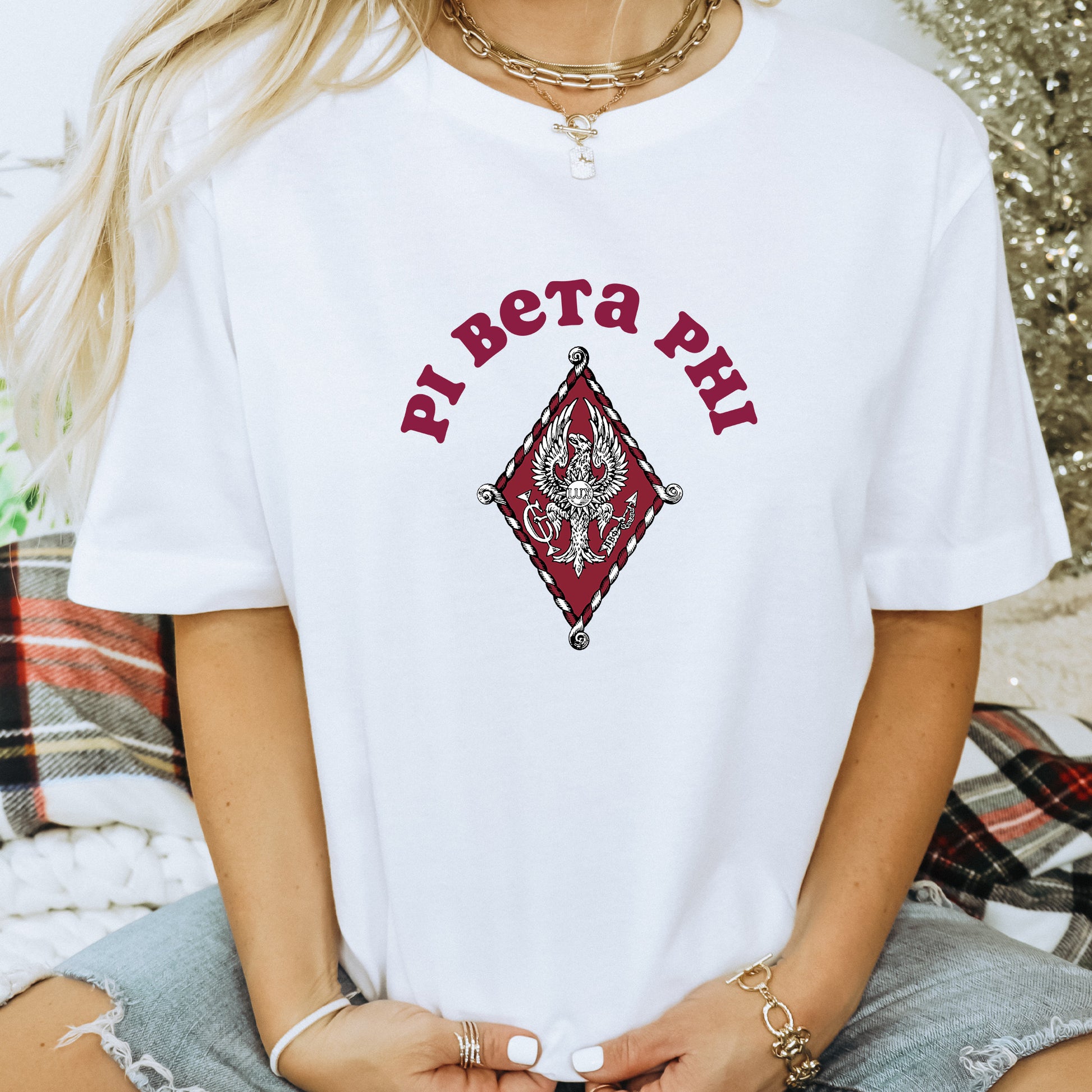 a woman wearing a white t - shirt with a red diamond on it
