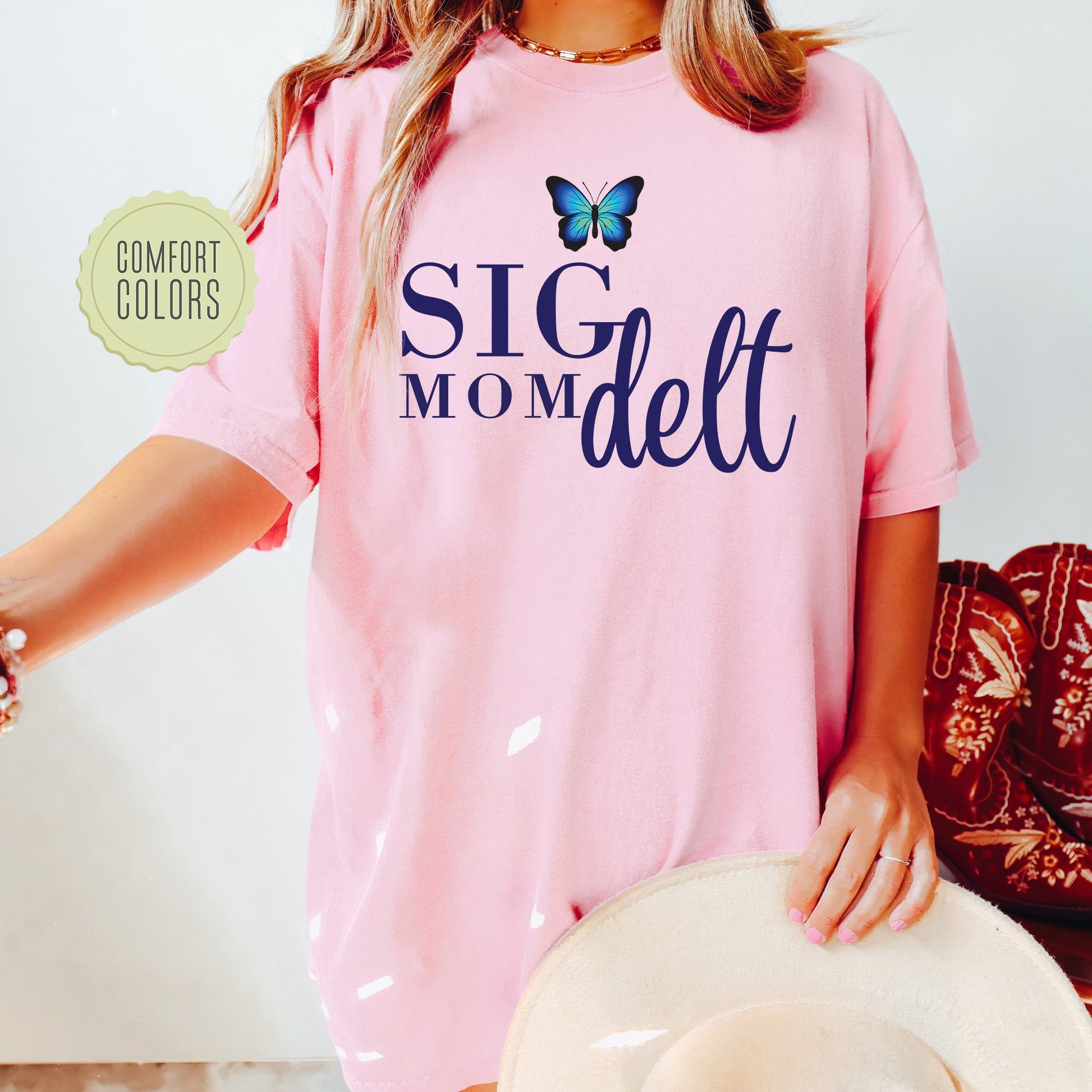a woman wearing a pink shirt with a butterfly on it