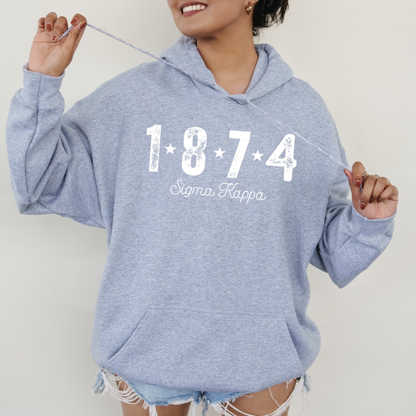 a woman in a blue hoodie holding a toothbrush