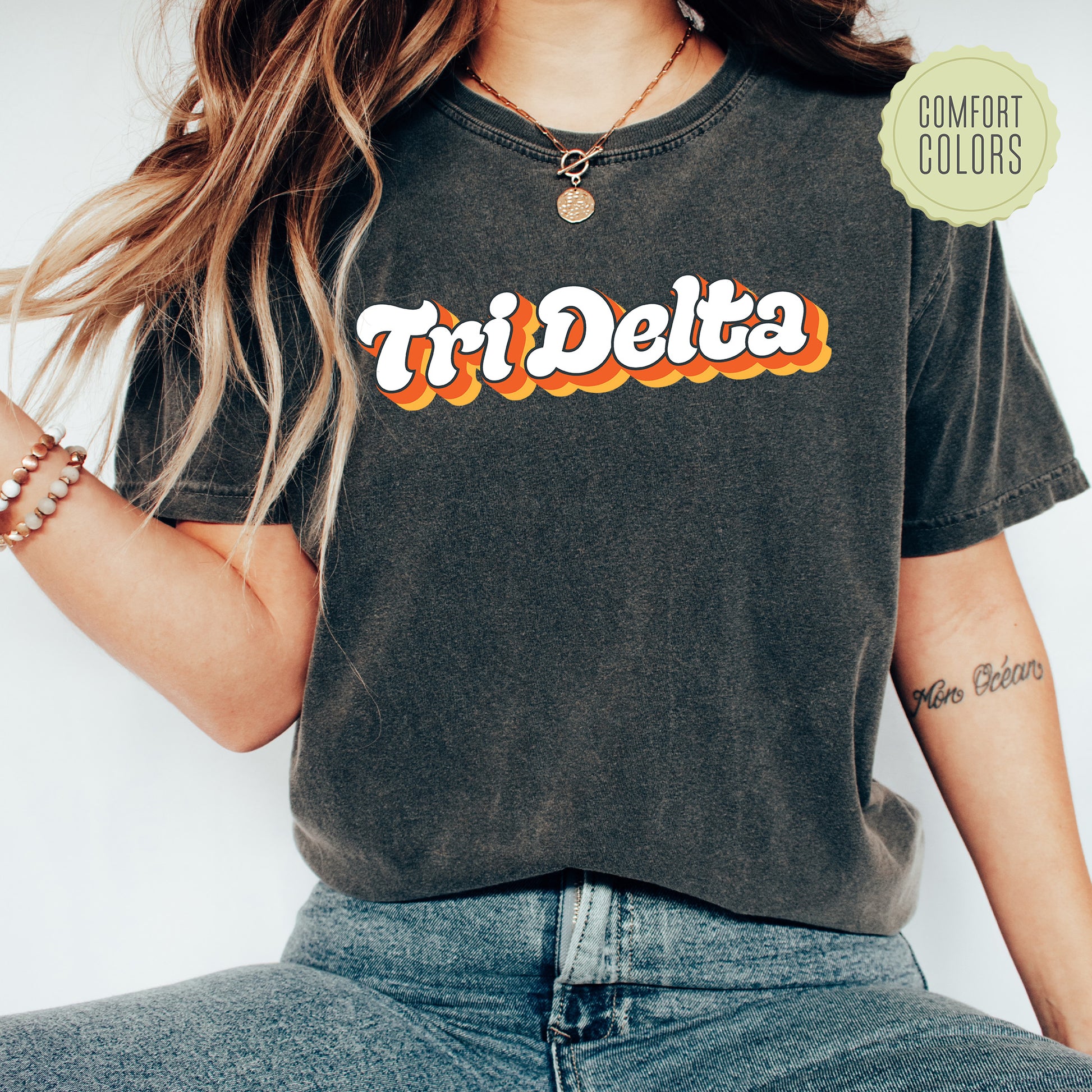 a woman wearing a t - shirt with the word tri delta on it