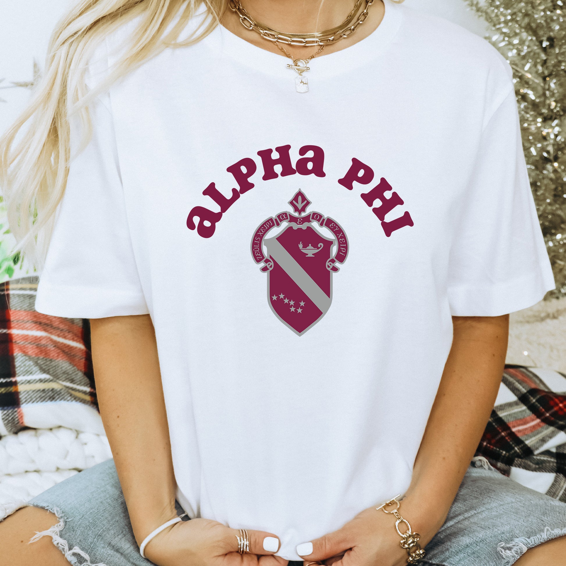 a woman wearing a white shirt with the words alpha phi on it