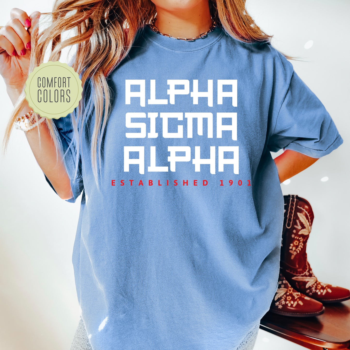 a woman wearing a blue shirt with the words alphia stigma alphia