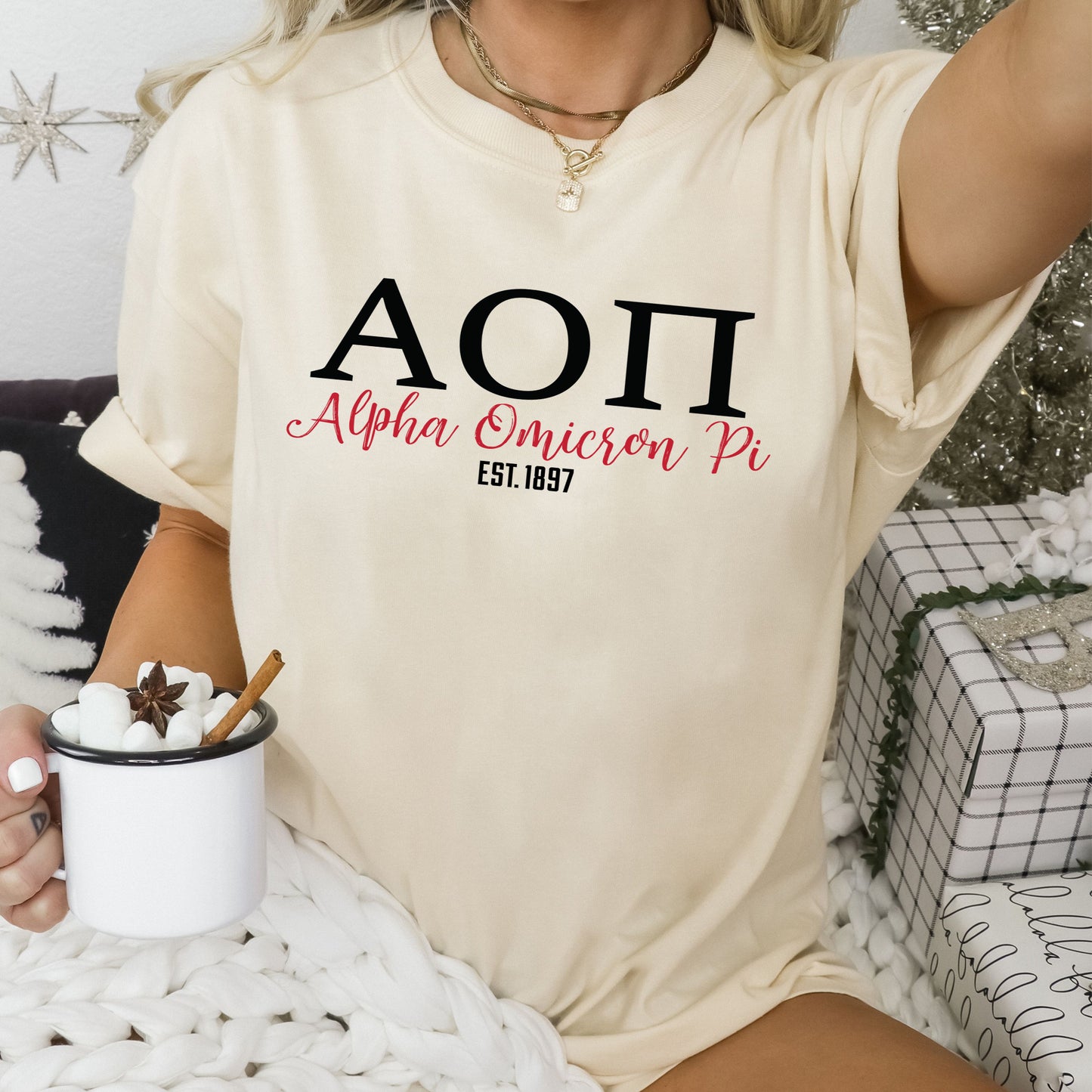 a woman sitting on a bed holding a cup of coffee