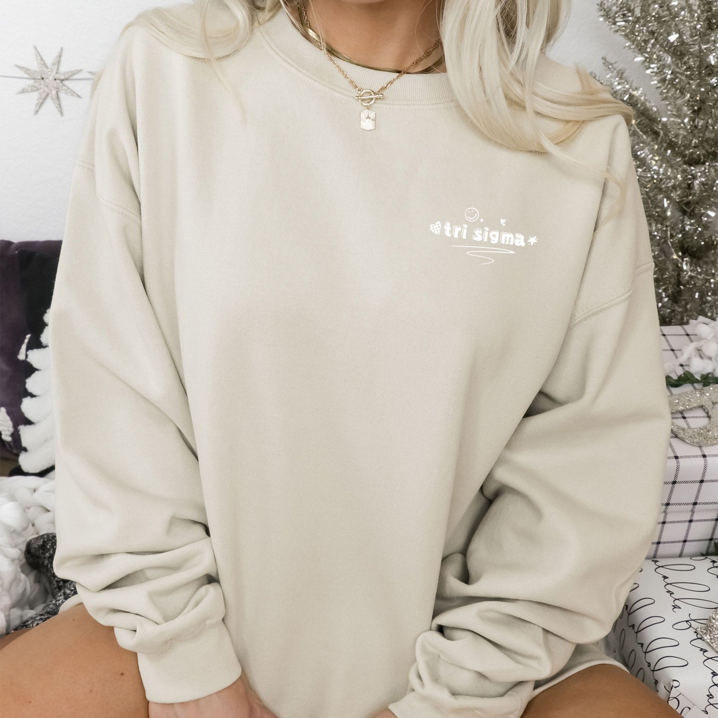 a woman sitting on a bed wearing a white sweatshirt