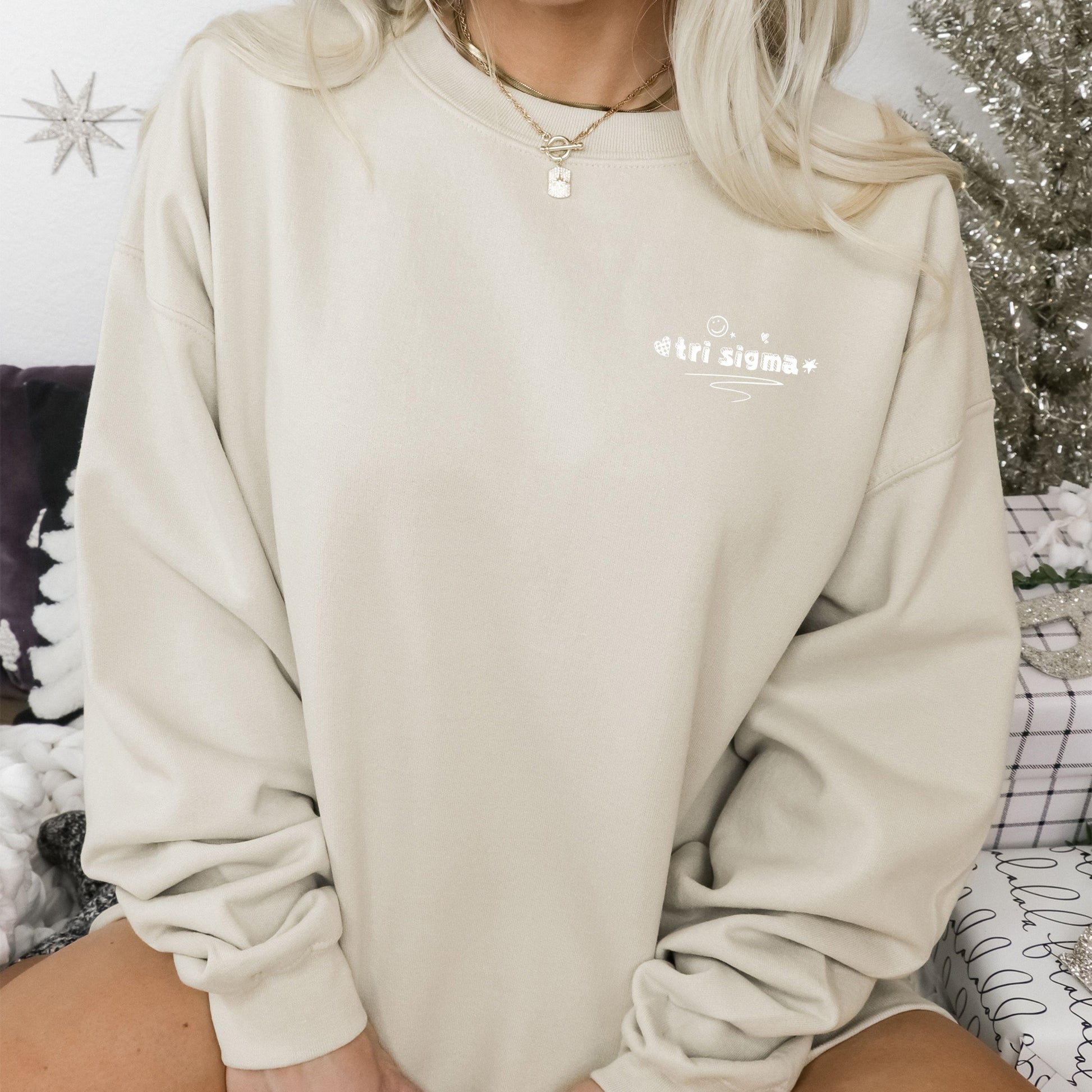 a woman sitting on a bed wearing a white sweatshirt