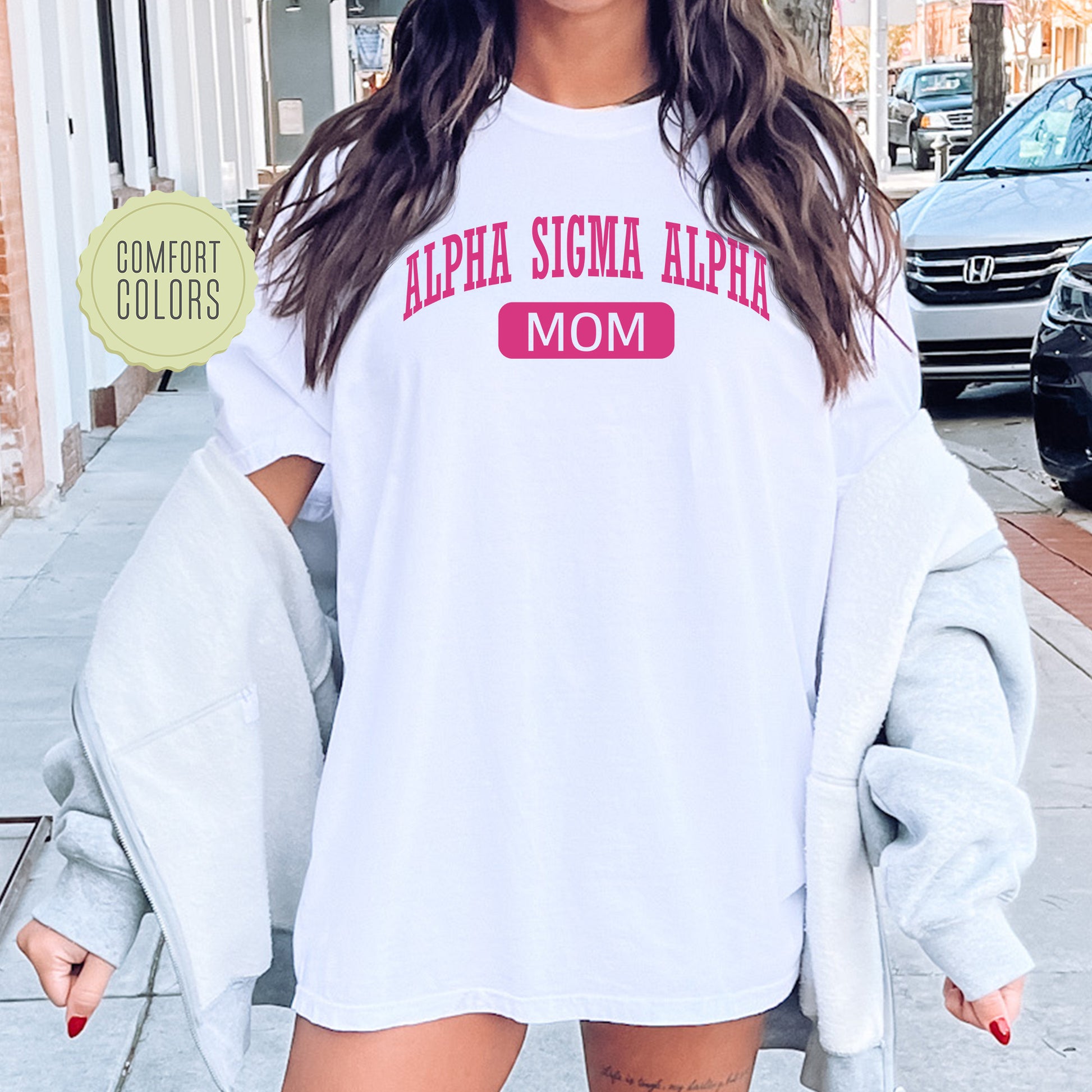 a woman wearing a white shirt with pink letters on it