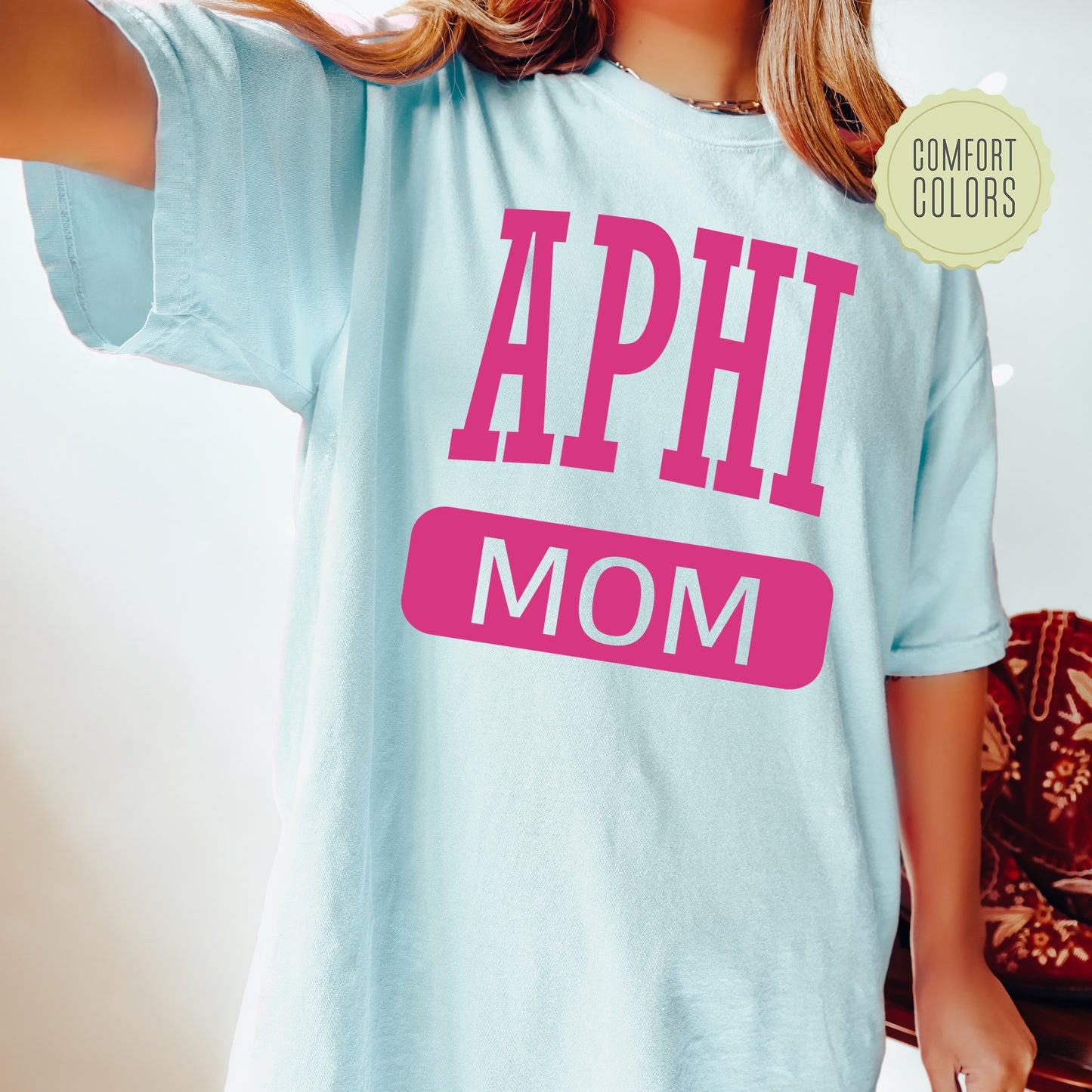 a woman wearing a shirt that says aphi mom