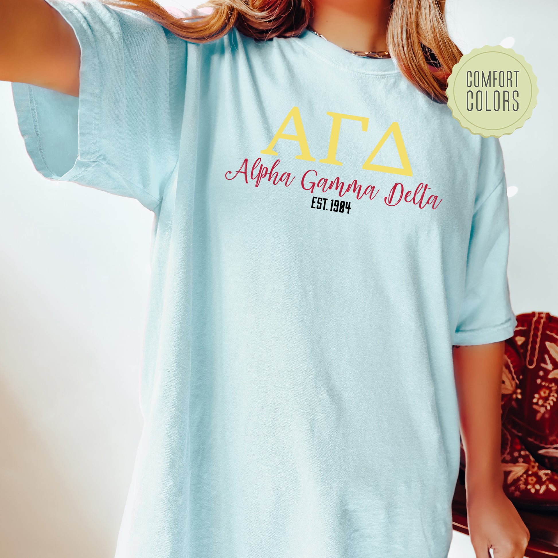 a woman wearing a light blue t - shirt with the words ata on it