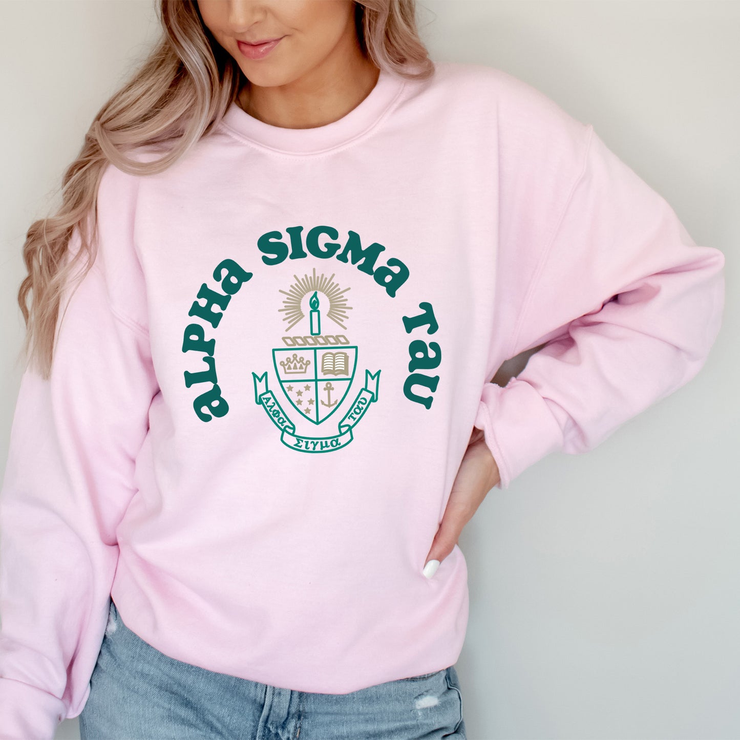 a woman wearing a pink sweatshirt and jeans