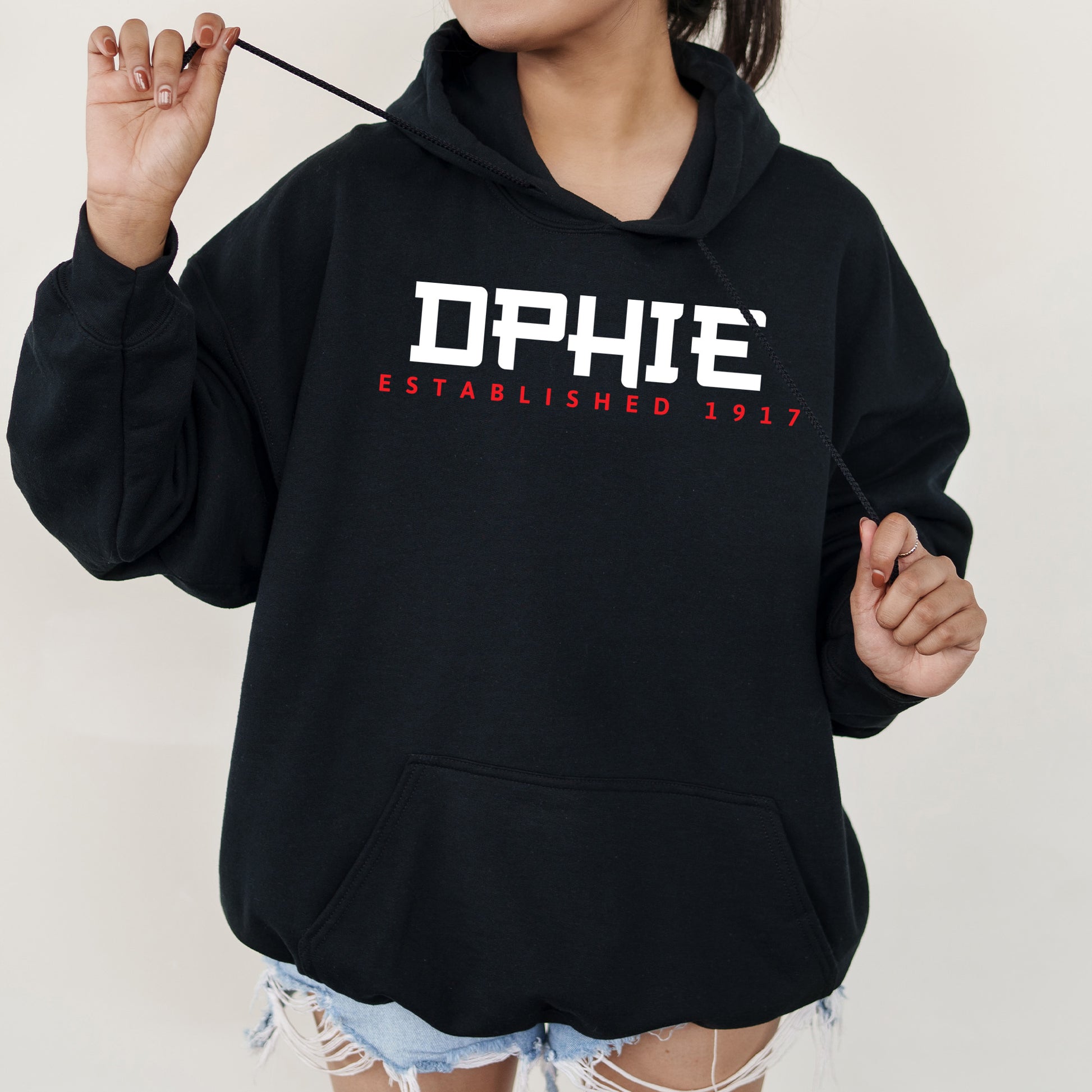 a woman in a black hoodie is holding a stick