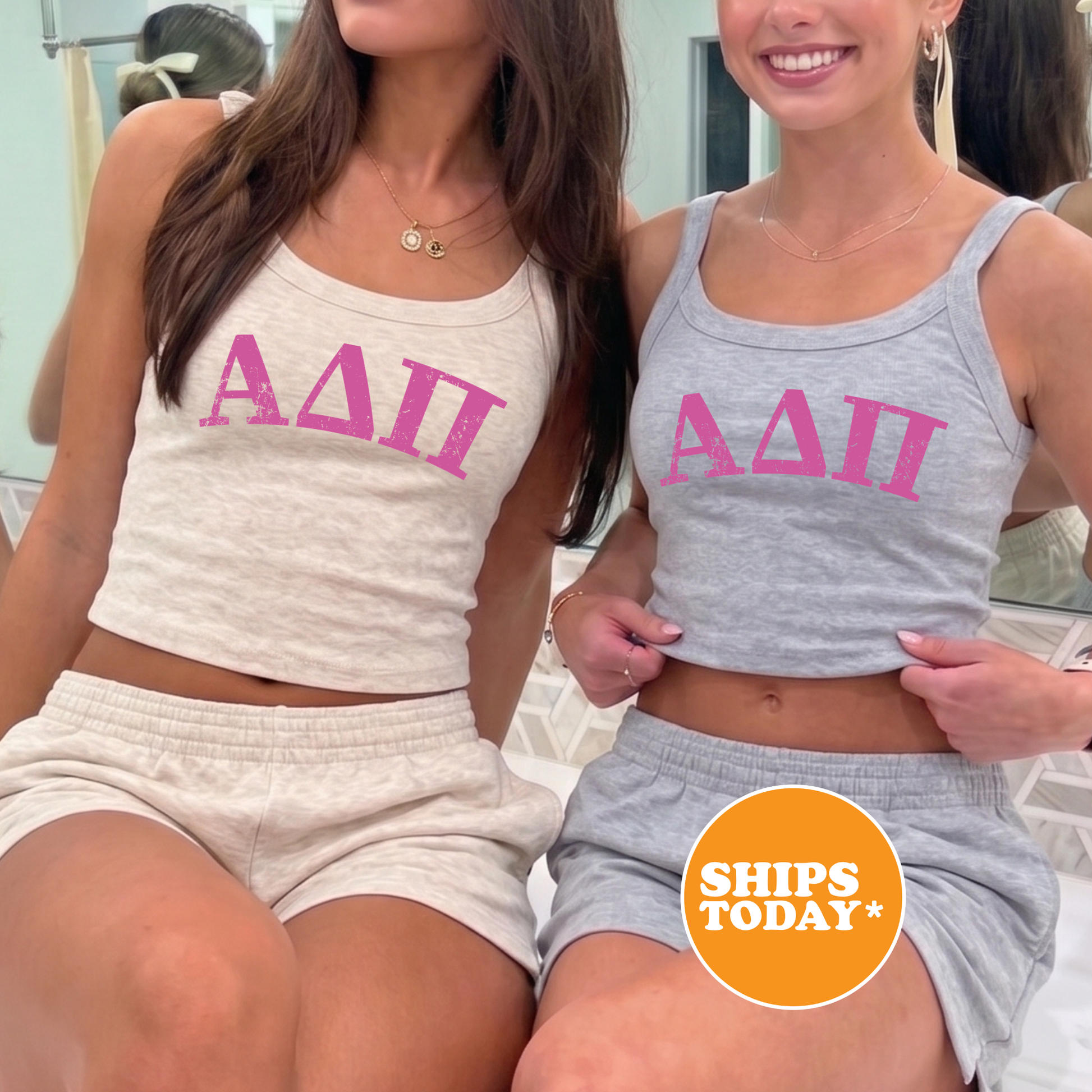 Two young women wearing tank tops with the letters 'ΔΩΓΟΣ' printed on them, smiling and posing together.