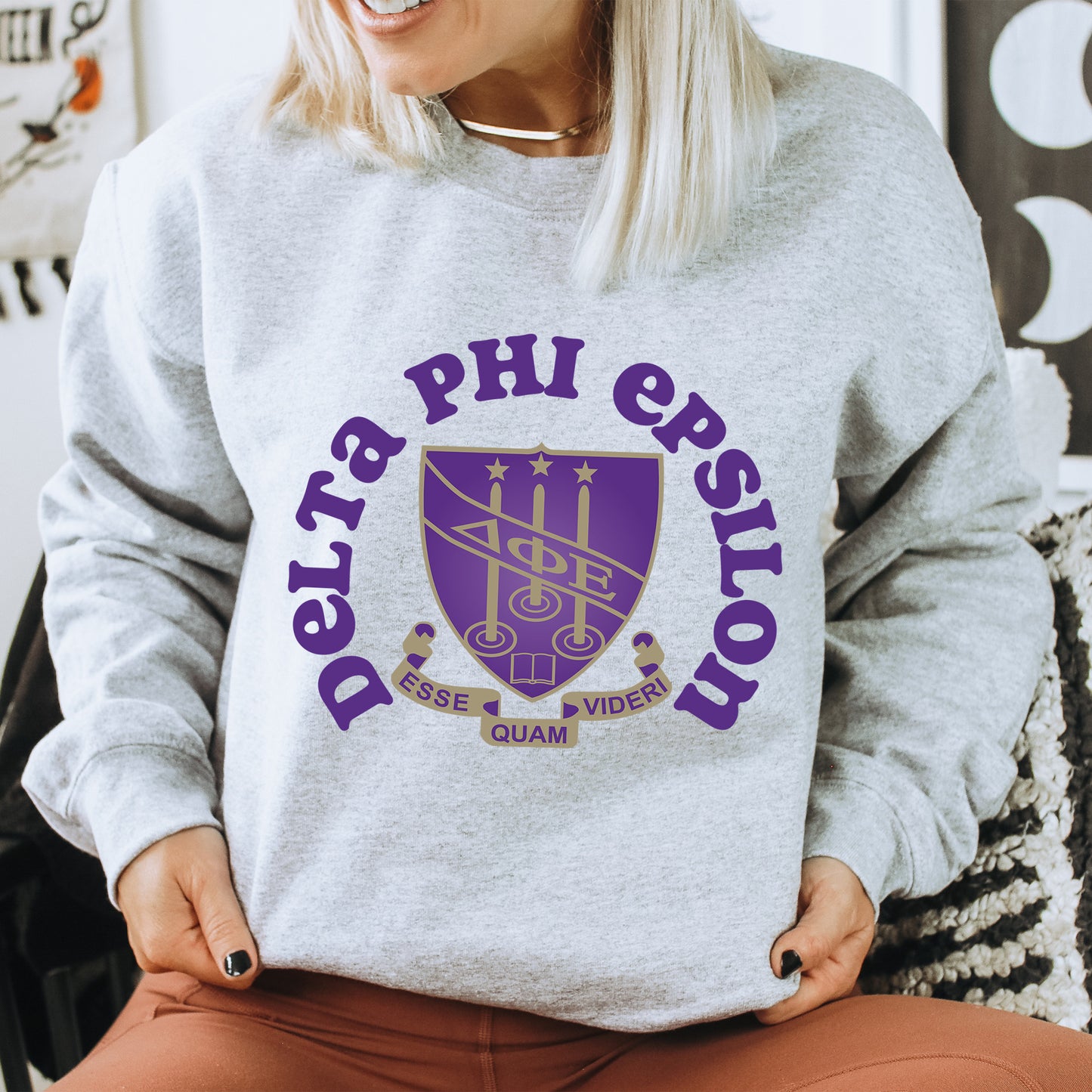 a woman sitting on a chair wearing a sweatshirt