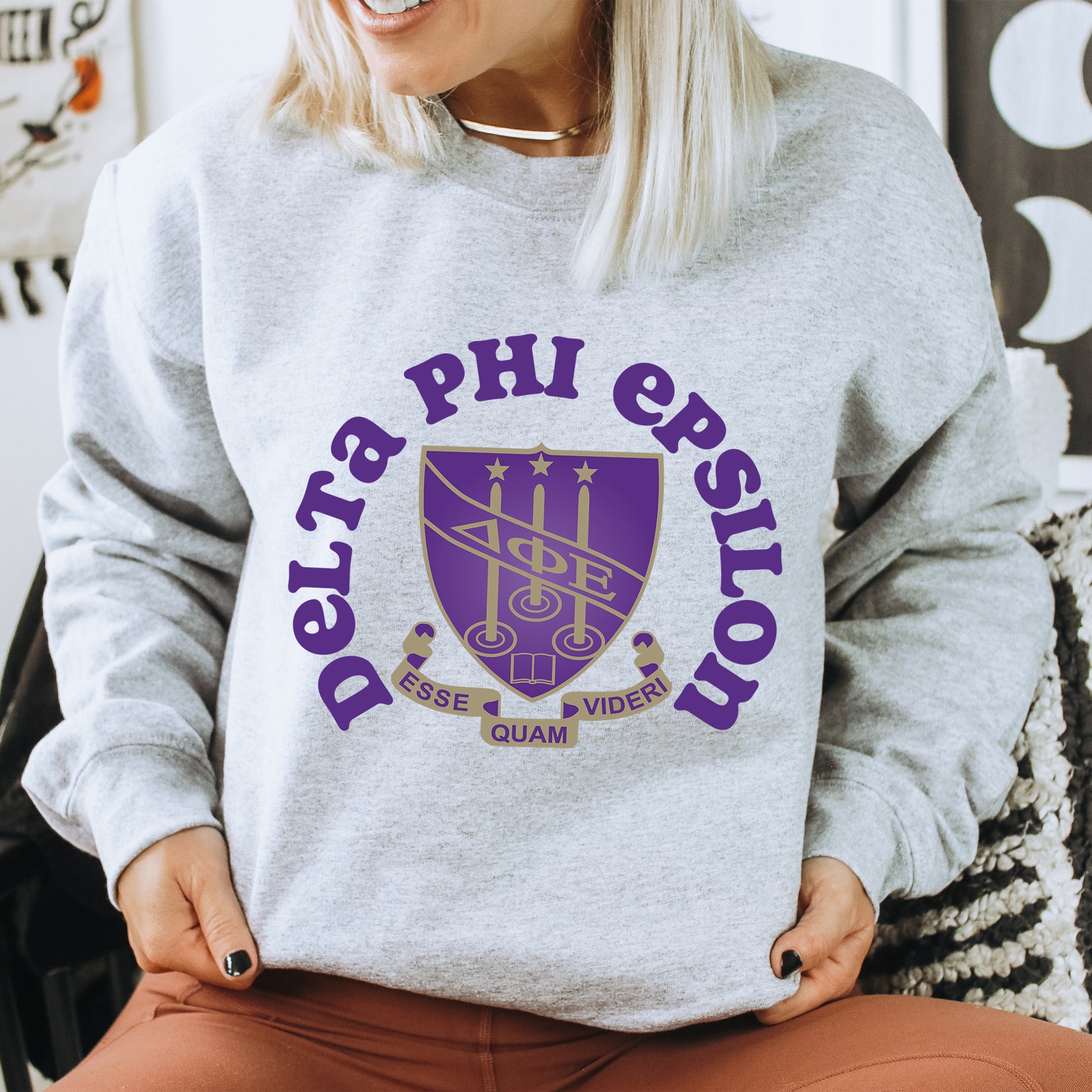 a woman sitting on a chair wearing a sweatshirt