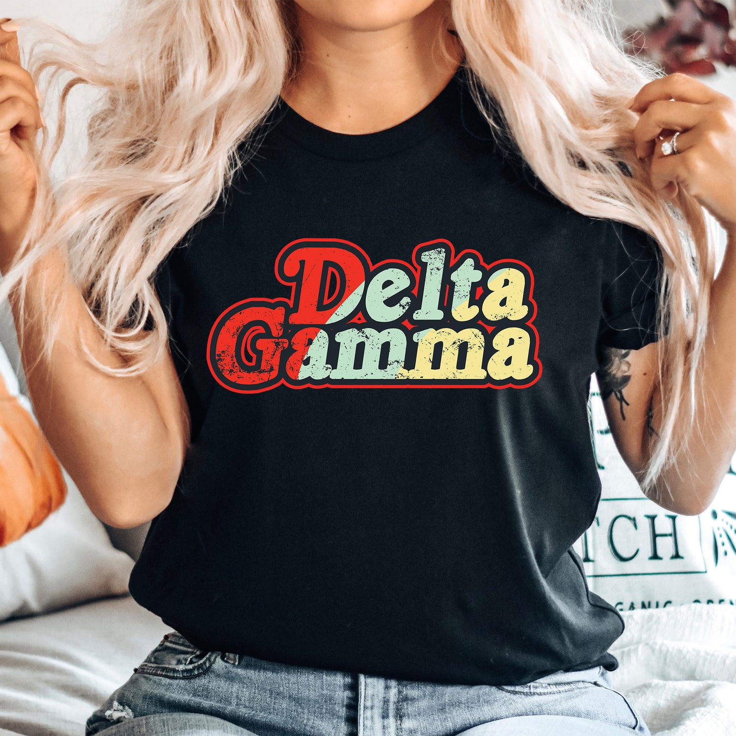 a woman with blonde hair wearing a black delta gumma t - shirt