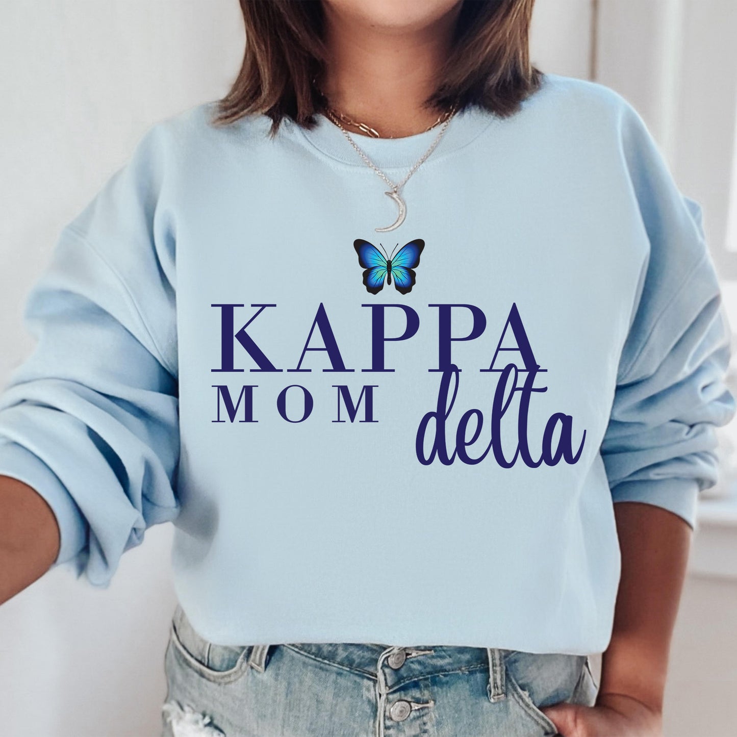 a woman wearing a sweatshirt that says kappa mom delta