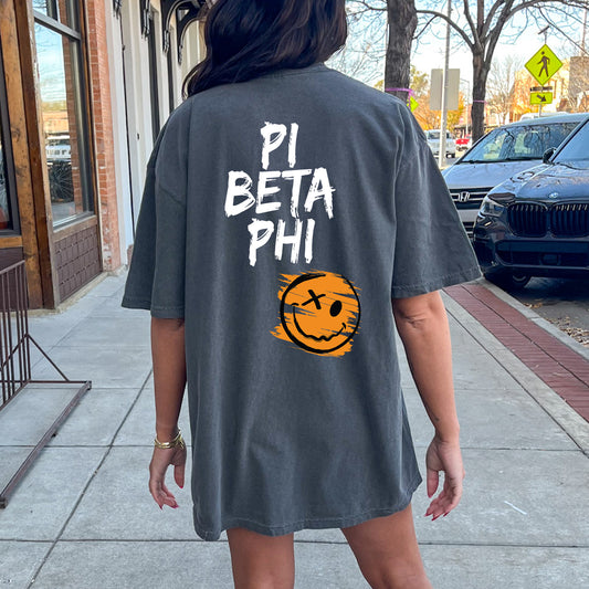 a woman walking down a sidewalk wearing a shirt that says pi beta phi