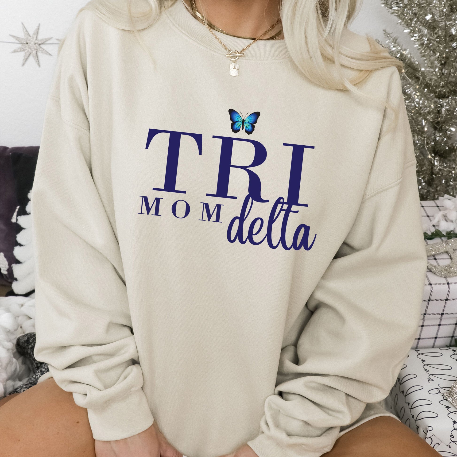 a woman sitting on a bed wearing a sweatshirt