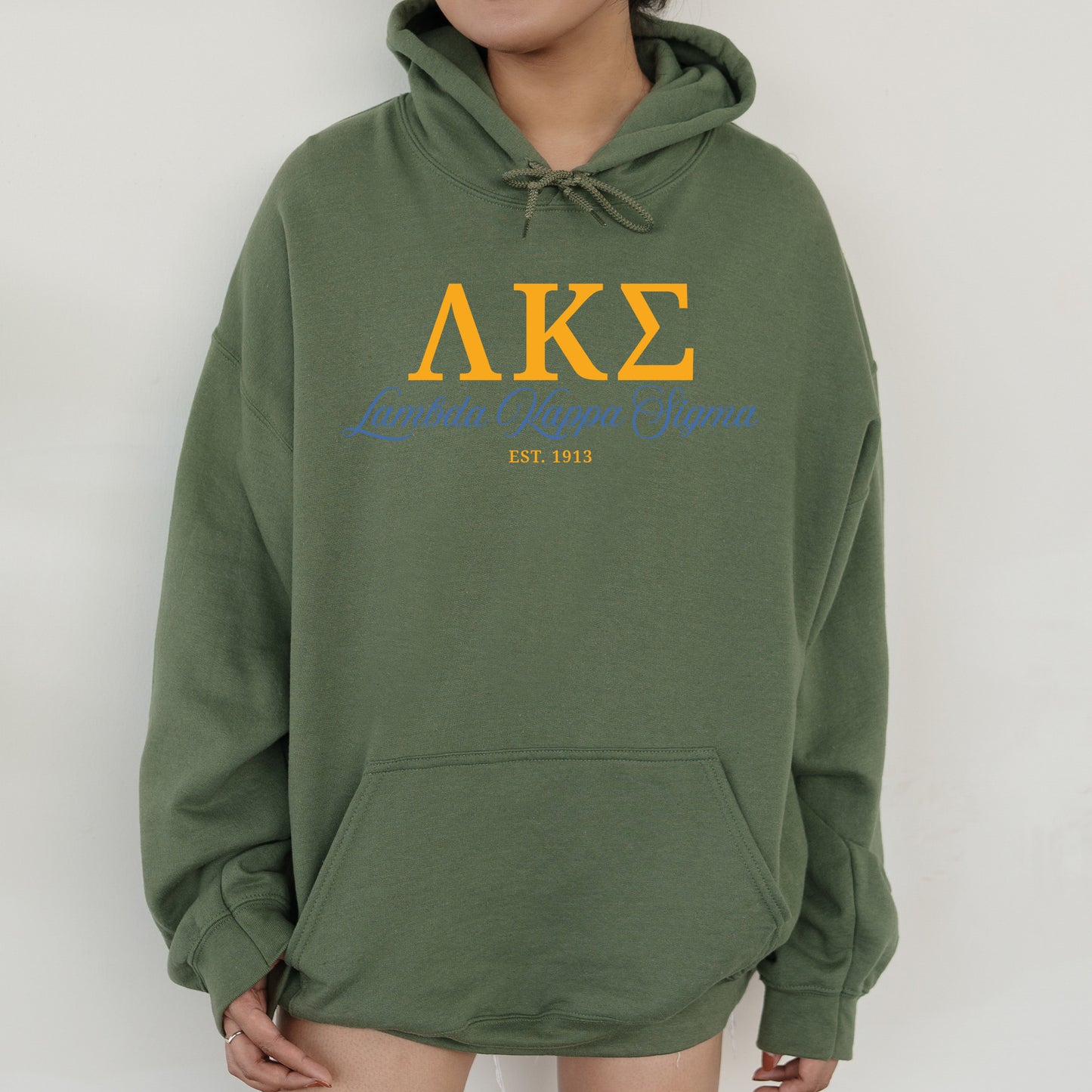 a person wearing a green hoodie with the letters ake on it