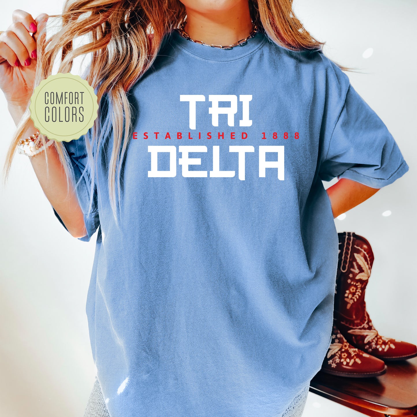 a woman wearing a blue t - shirt with the words tri started with delta on