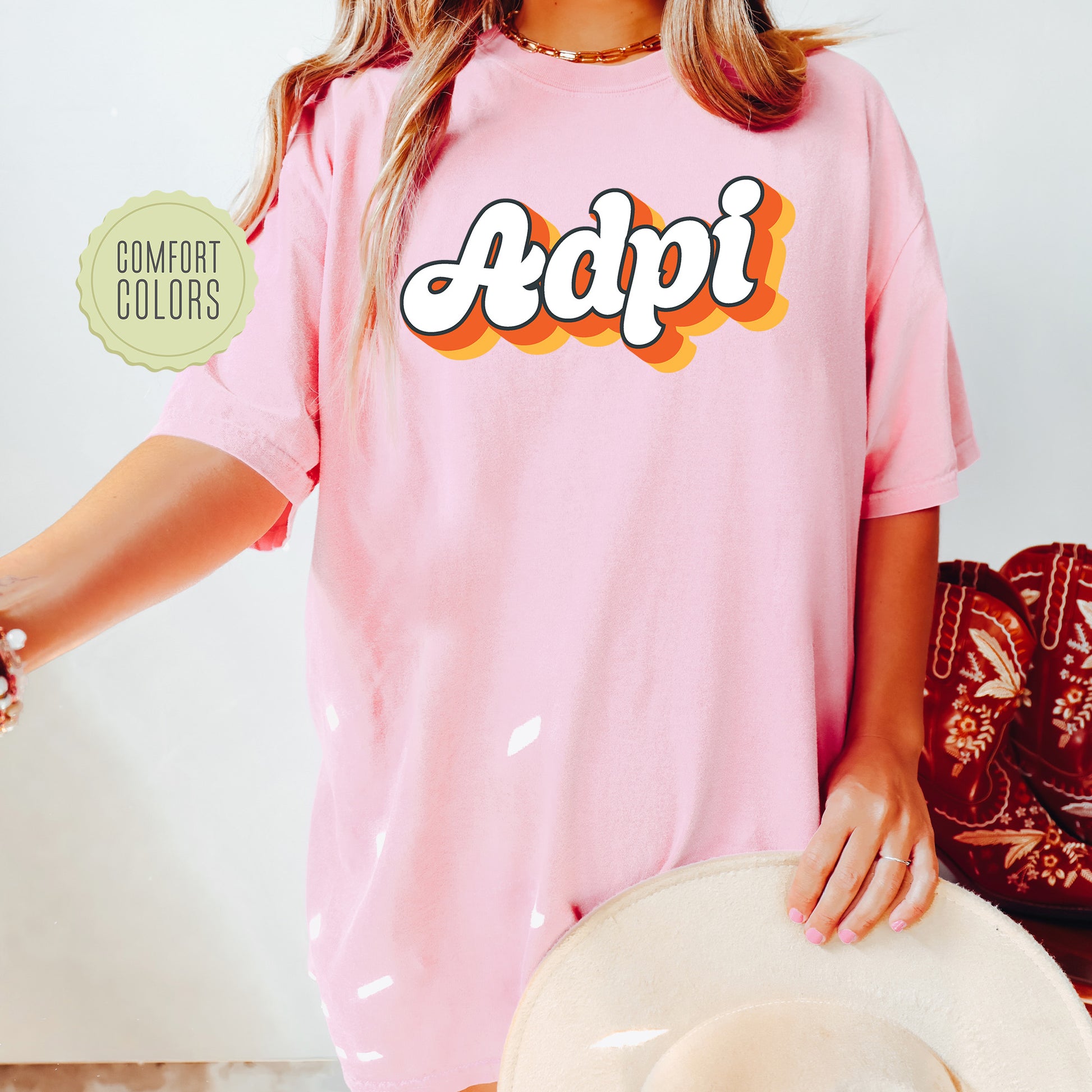 a woman wearing a pink shirt with the word adpi on it
