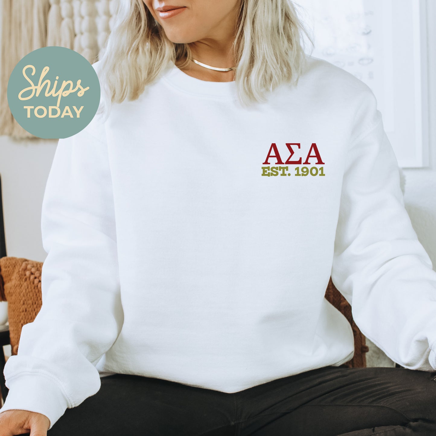 a woman sitting on a chair wearing a white sweatshirt