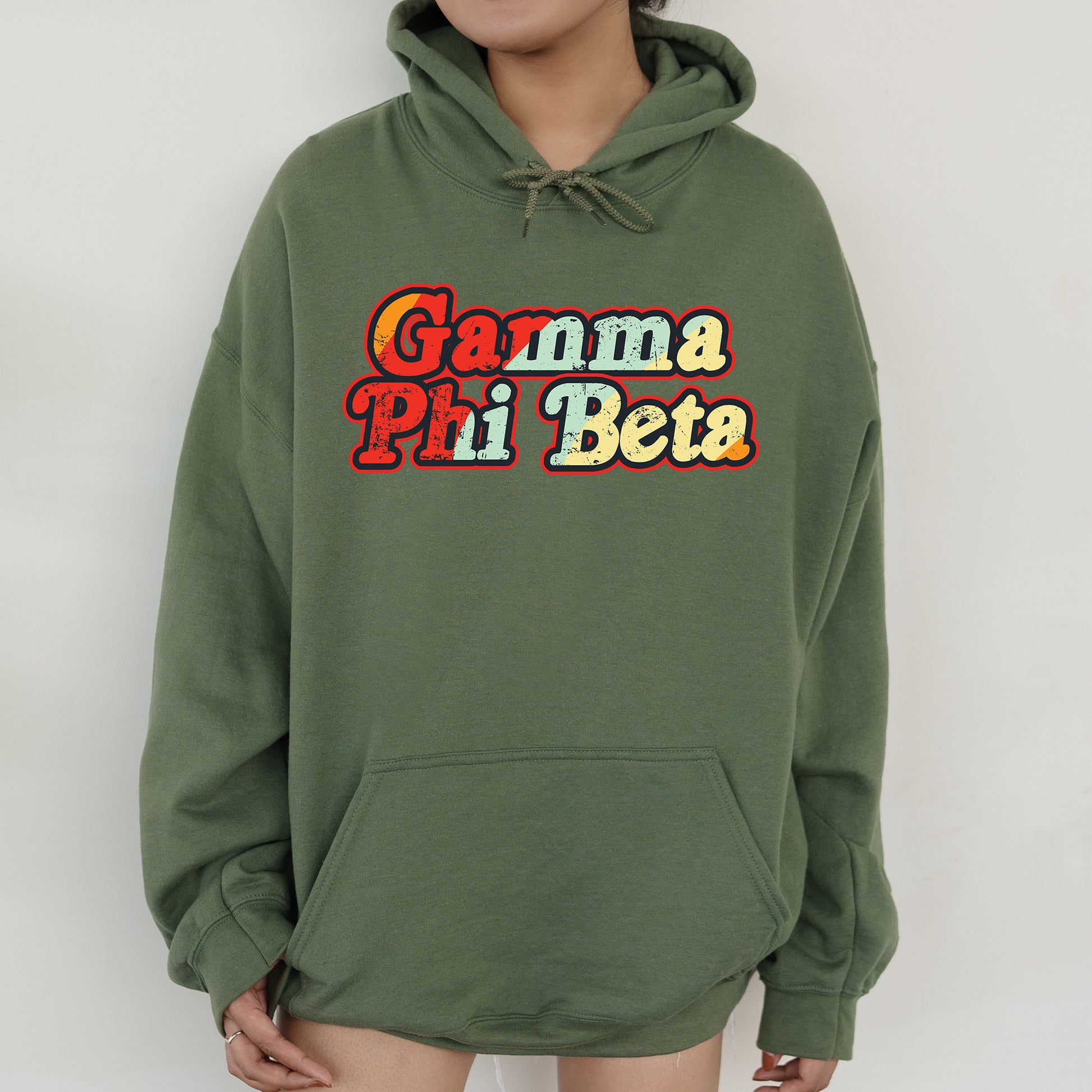 a woman wearing a green hoodie with the words gama pii beta