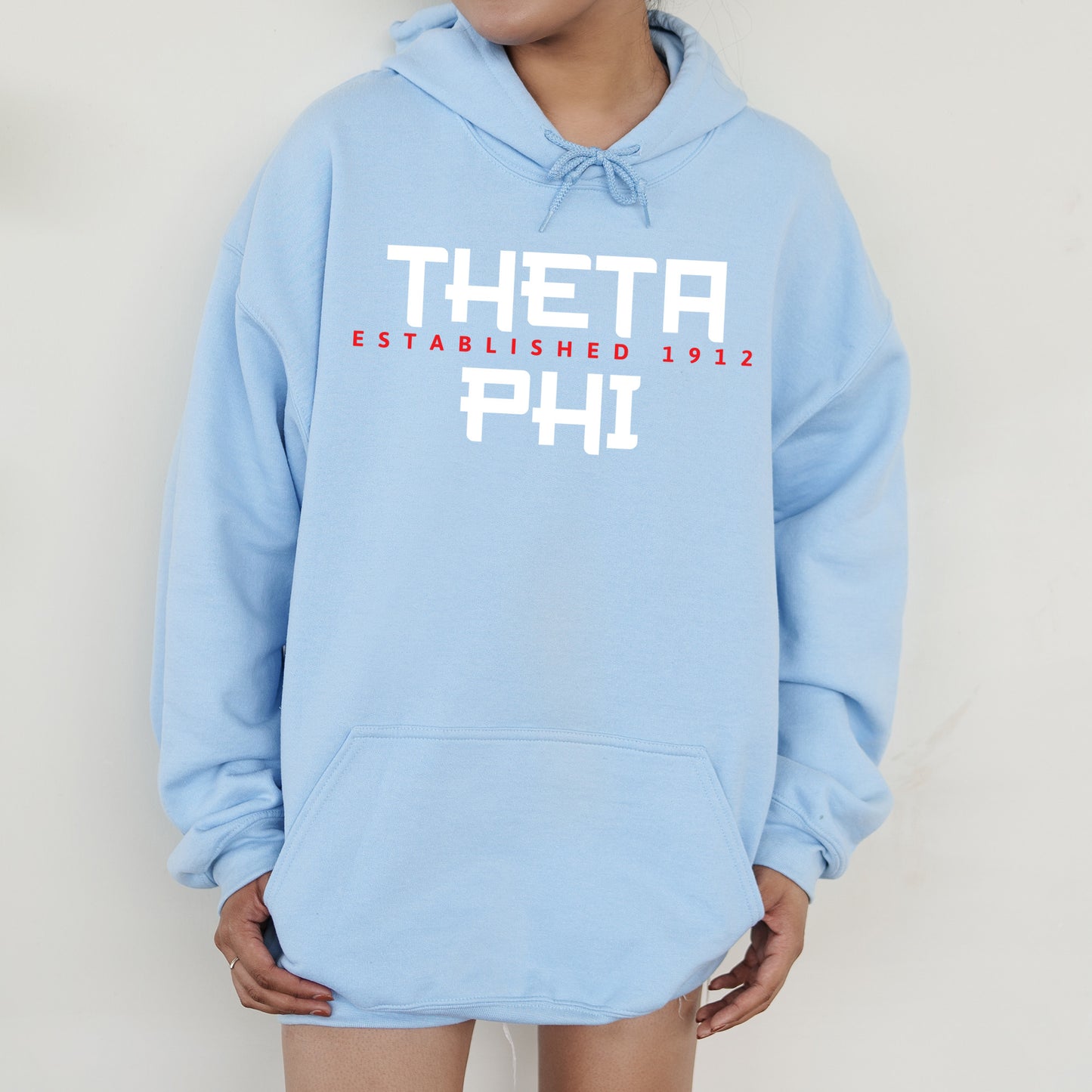 a person wearing a blue hoodie with the words thea on it