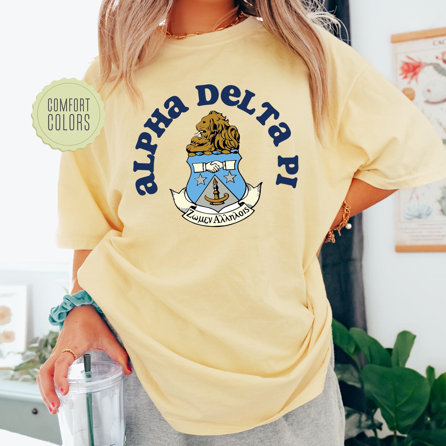 a woman in a yellow shirt is holding a drink