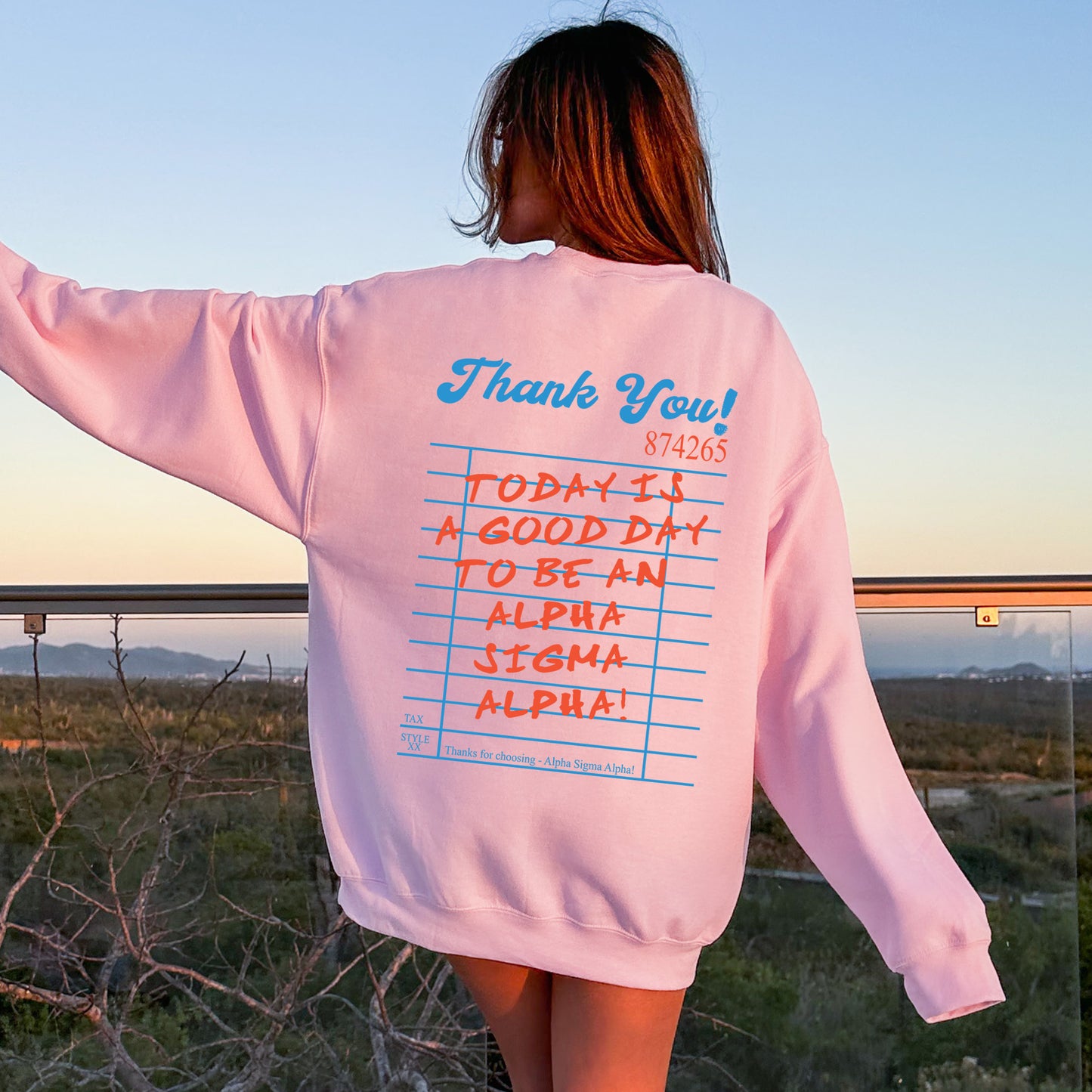 a woman wearing a pink sweatshirt with writing on it