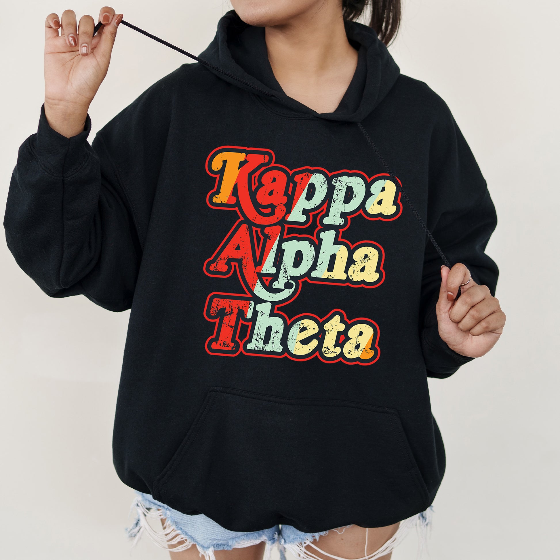 a woman wearing a black hoodie with the words kapppa alpha the