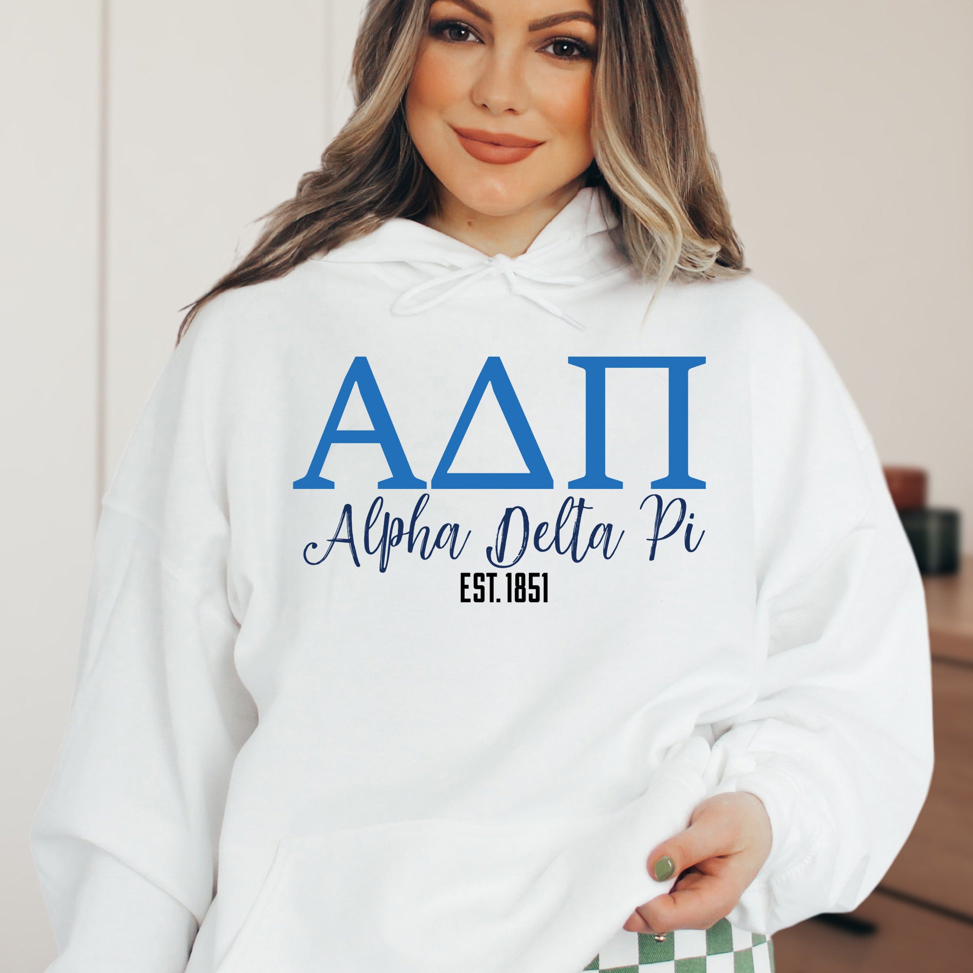 a woman wearing a white hoodie with blue letters on it