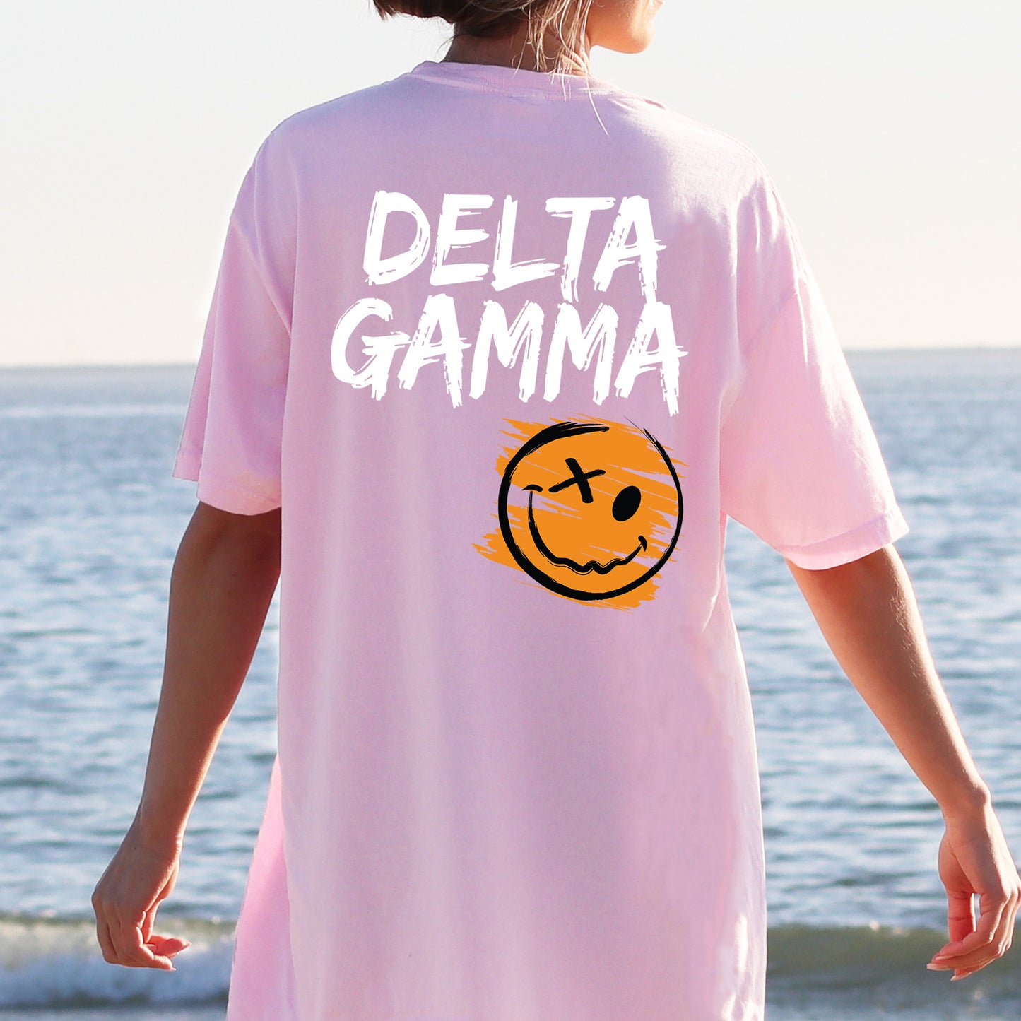 a person wearing a pink shirt with a smiley face on it