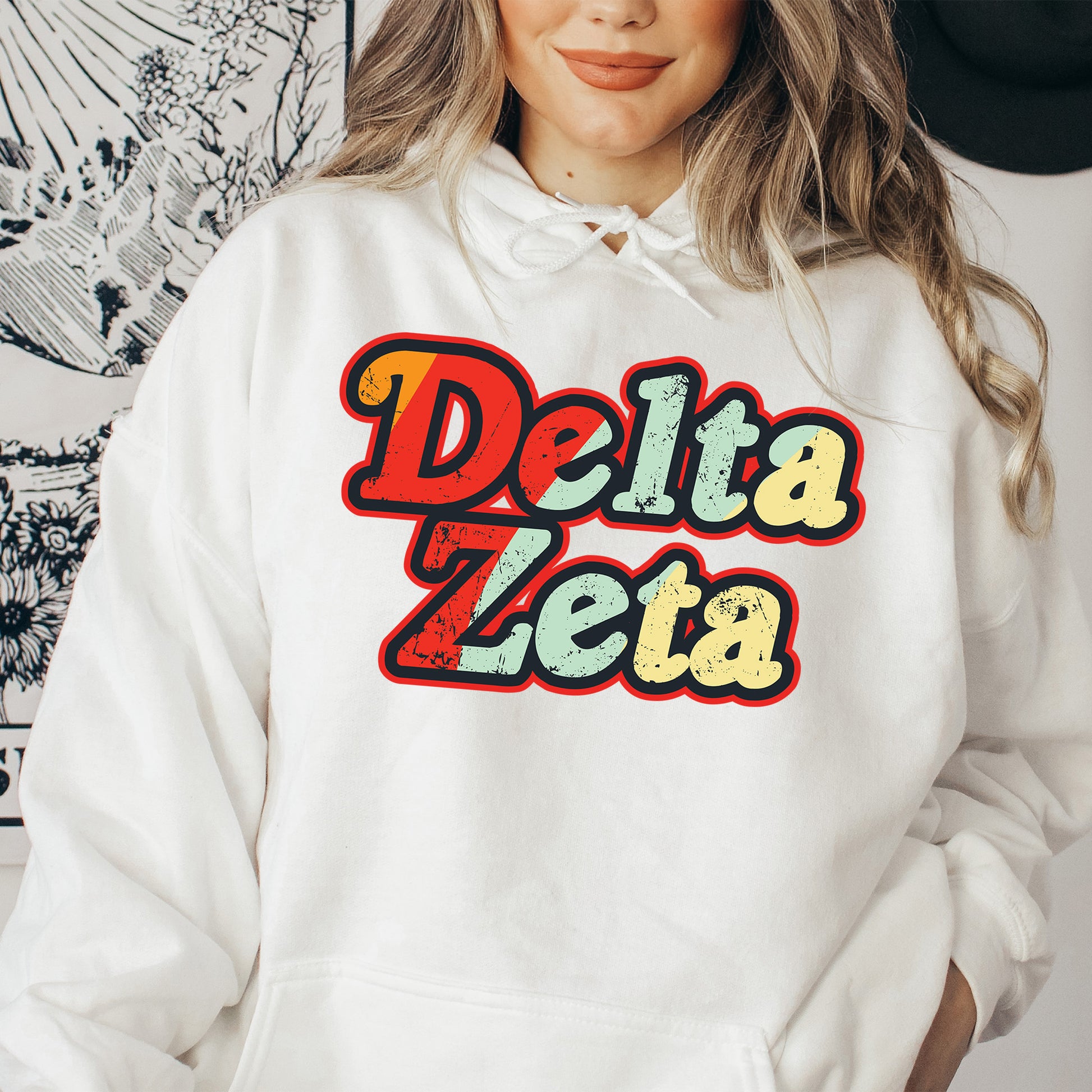 a woman wearing a white hoodie that says delta zeba