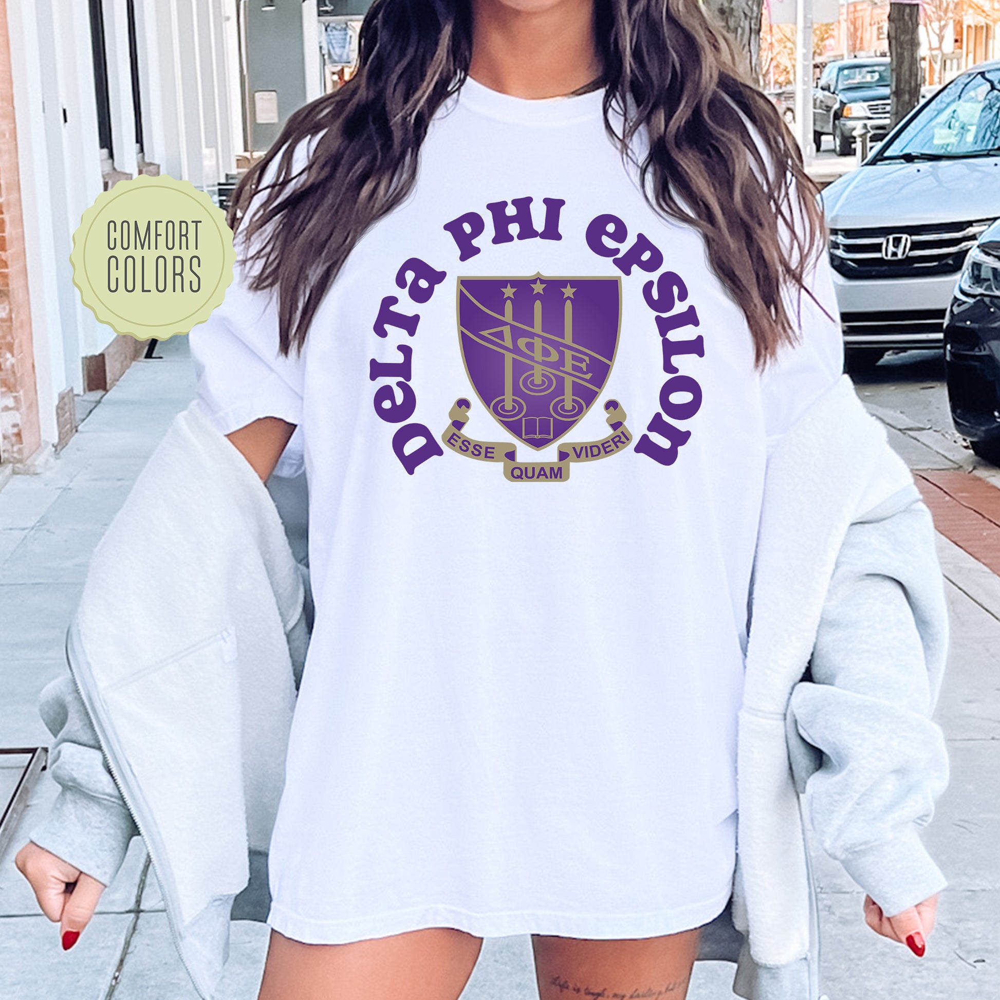 a woman wearing a white shirt with purple letters on it