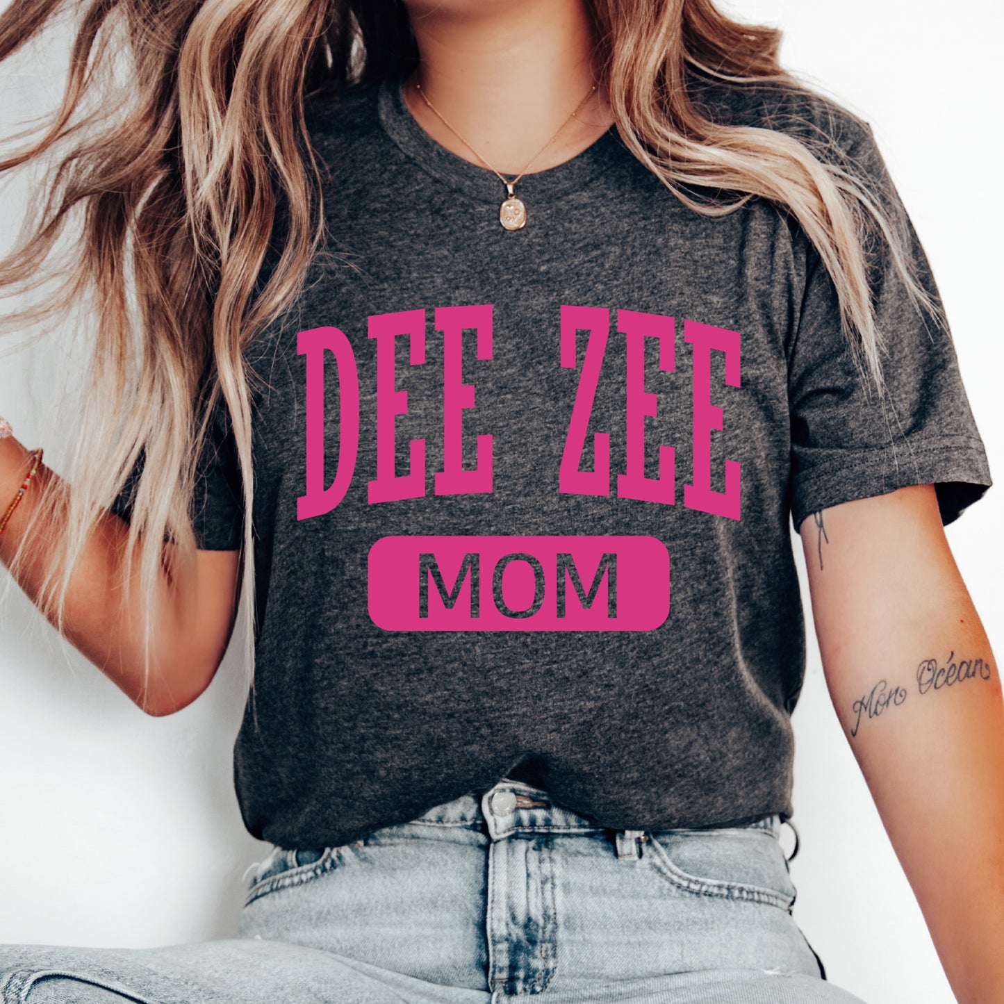 a woman wearing a t - shirt that says dee zee mom