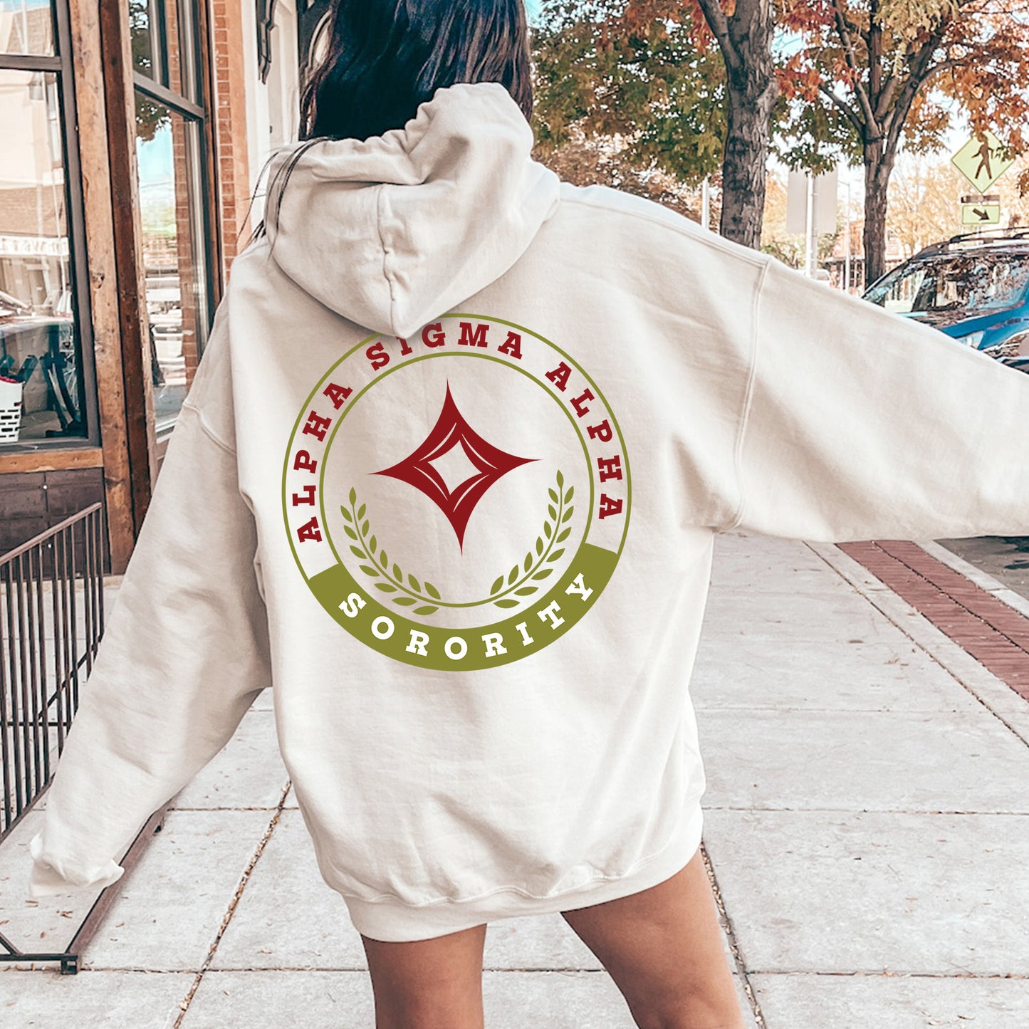 a woman in a white hoodie walking down a sidewalk