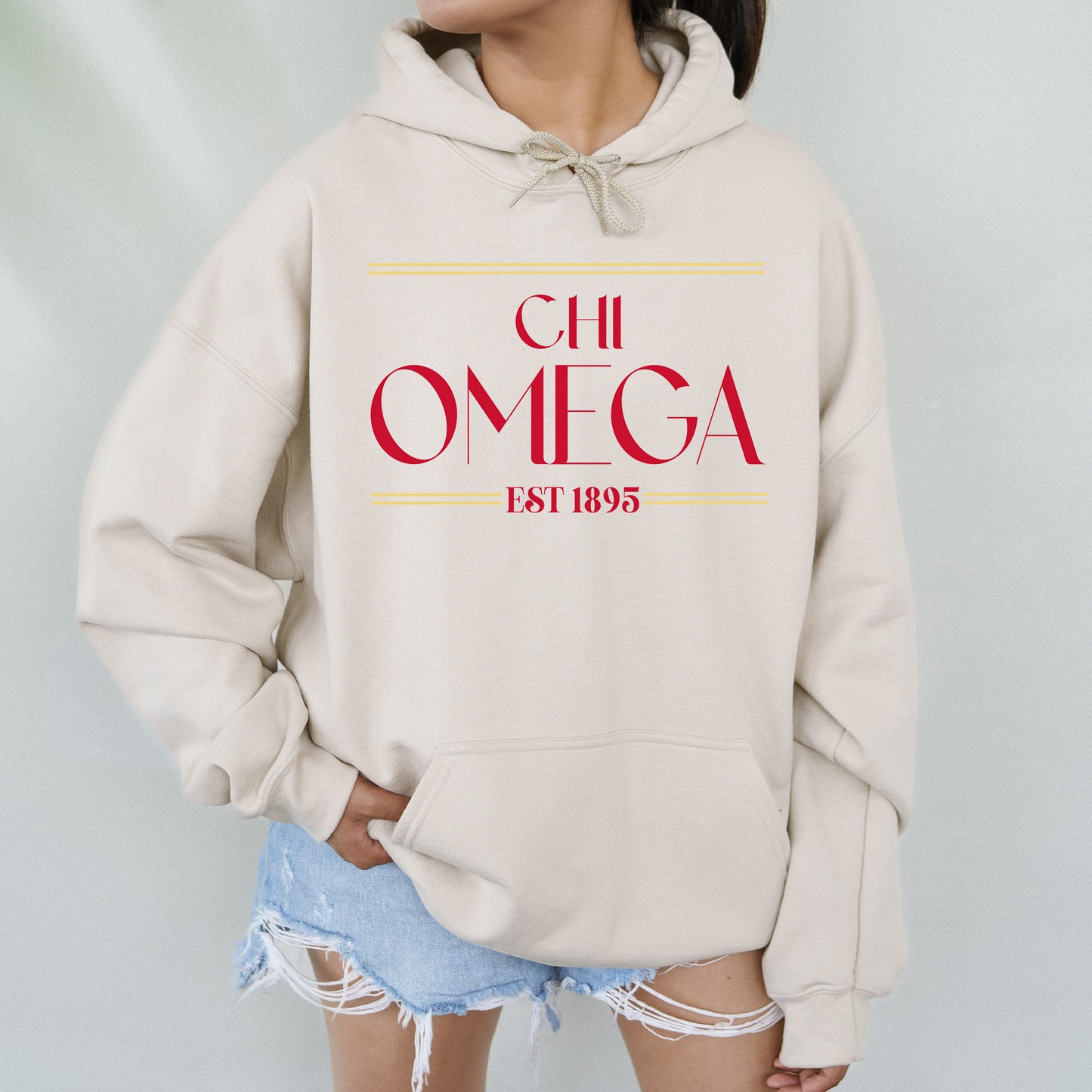 a woman wearing a white hoodie with a red omega on it