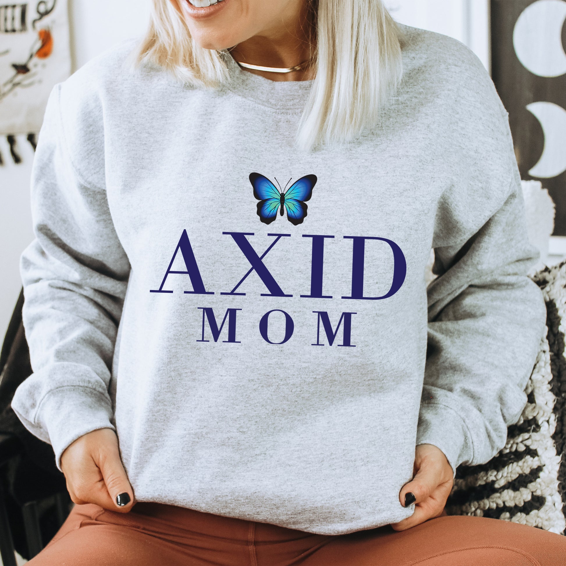 a woman wearing a sweatshirt that says axid mom