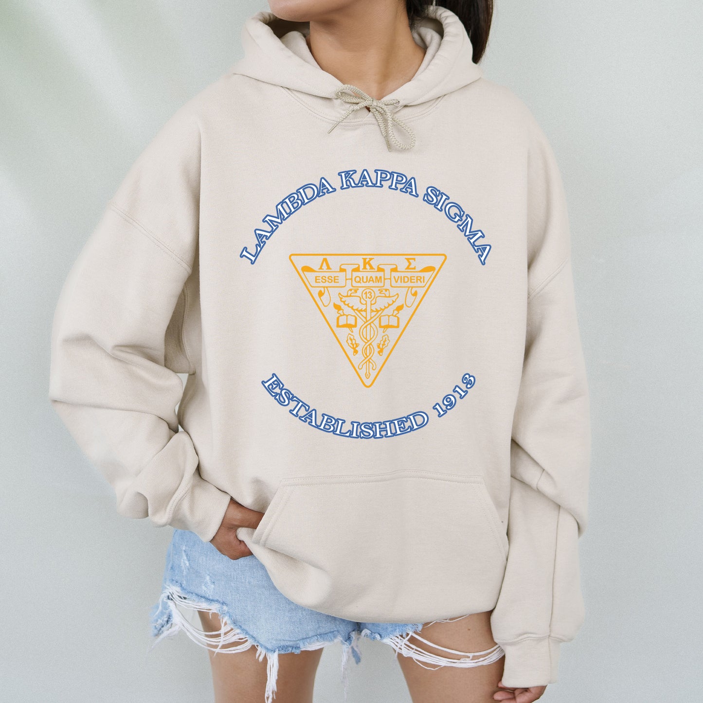 a woman wearing a white hoodie with a yellow triangle on it