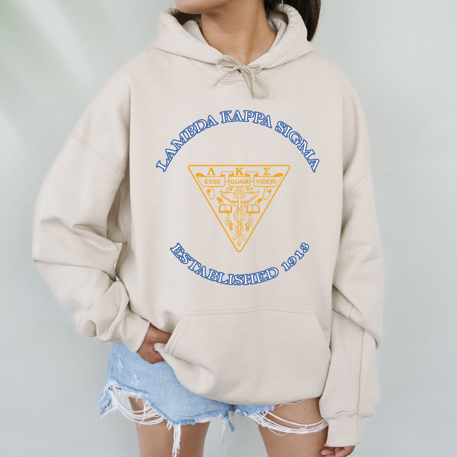 a woman wearing a white hoodie with a yellow triangle on it