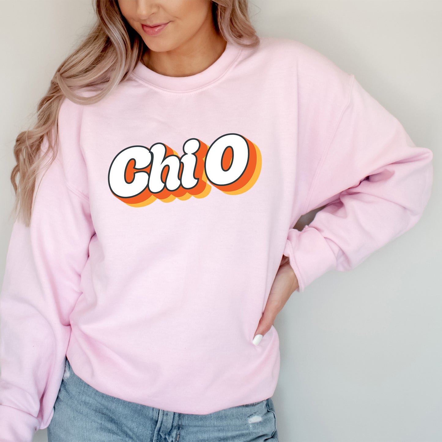 a woman wearing a pink sweatshirt with the word chio on it