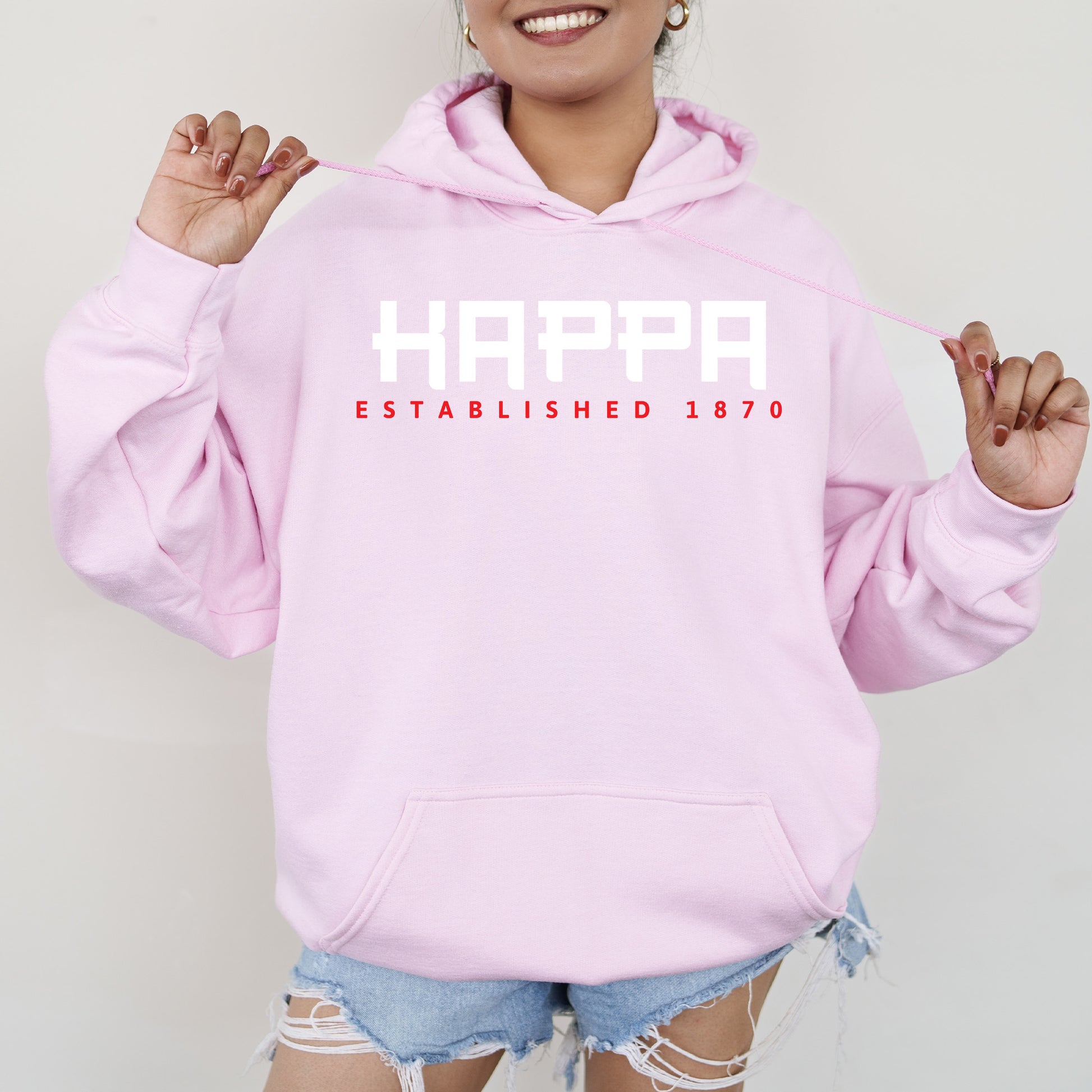 a woman wearing a pink happy established hoodie