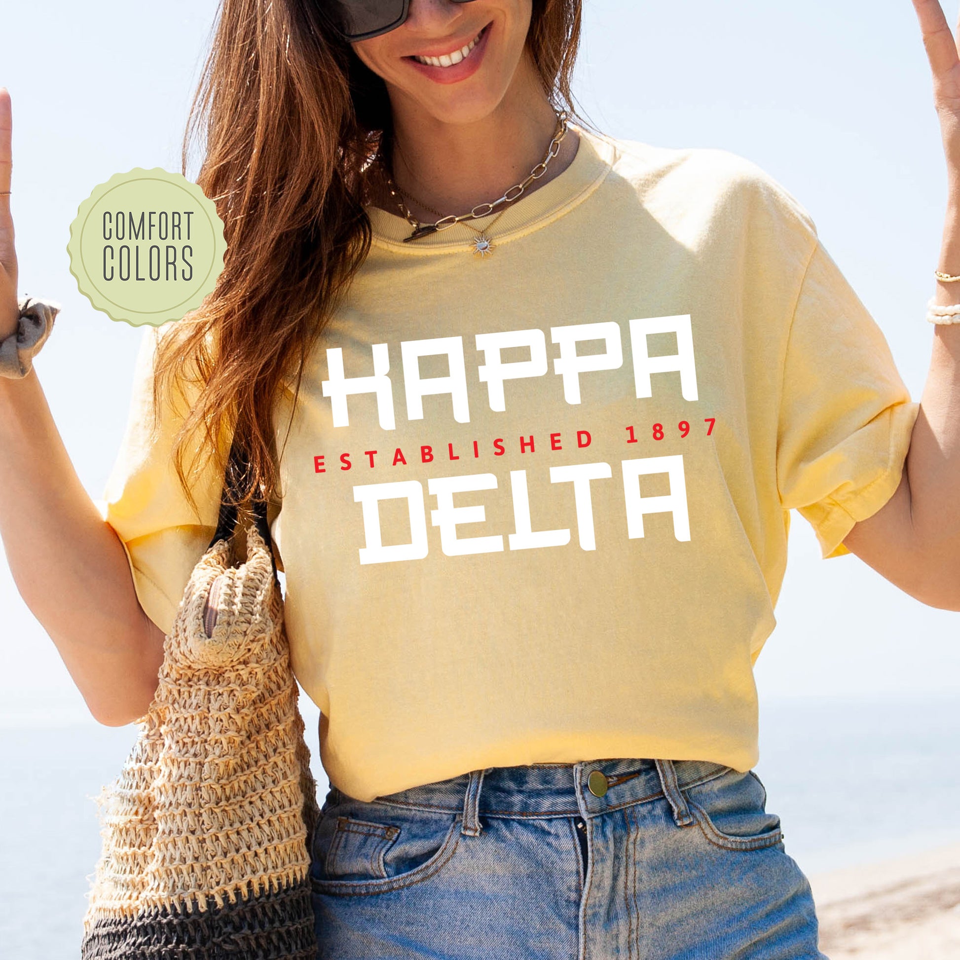a woman wearing a happy delta shirt and holding a purse