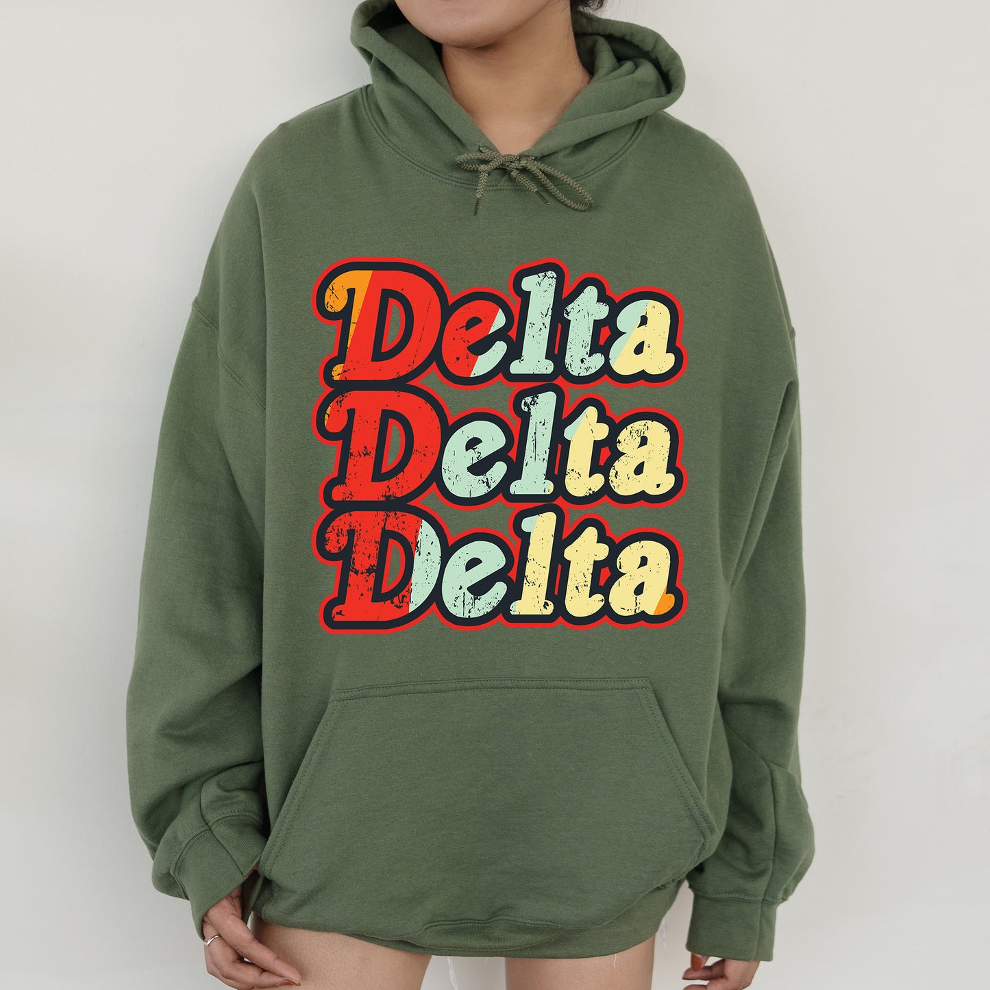 a woman wearing a green hoodie with the words delta delta on it