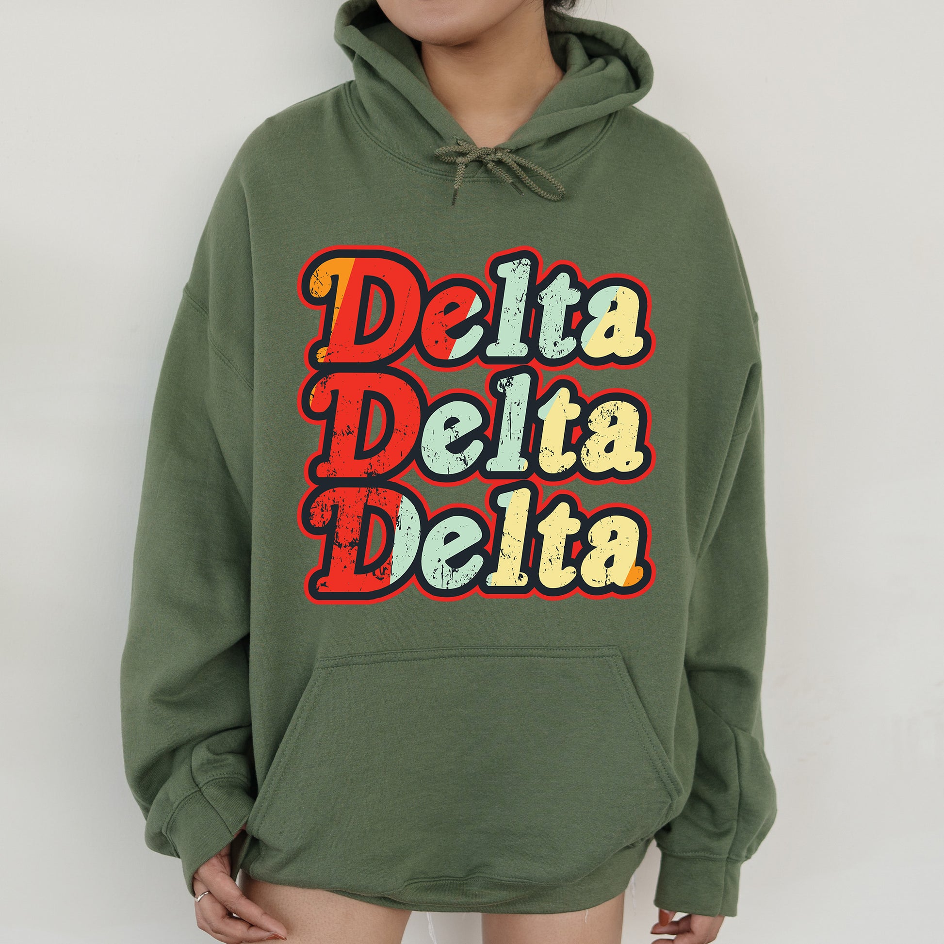 a woman wearing a green hoodie with the words delta delta on it