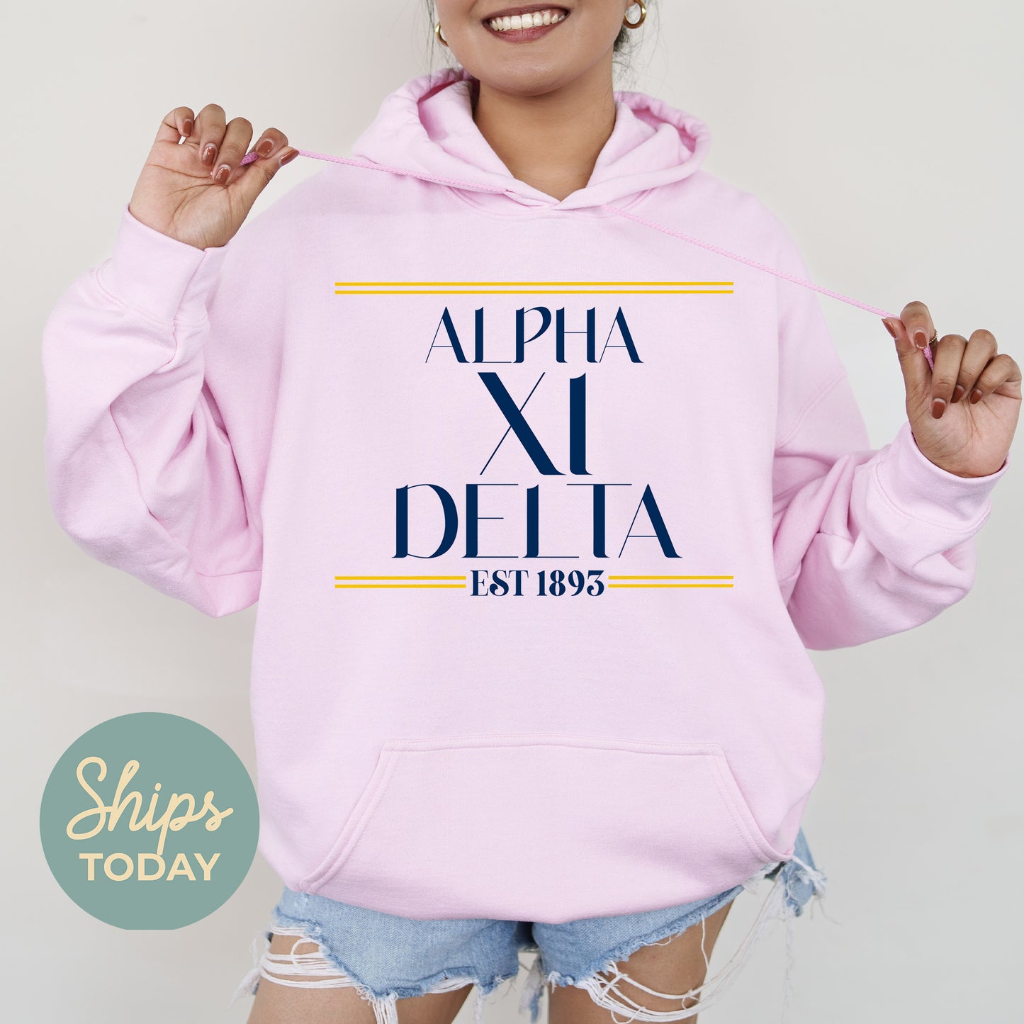 a woman wearing a pink hoodie with the word delta printed on it