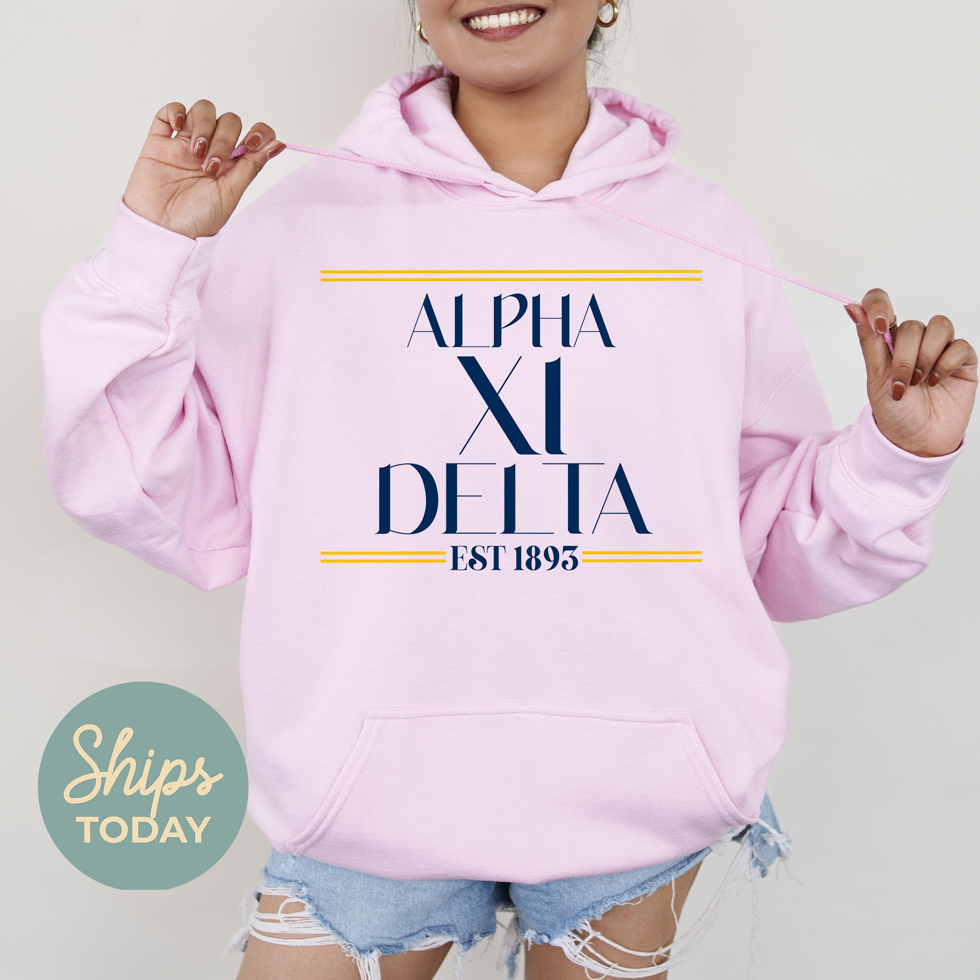 a woman wearing a pink hoodie with the word delta printed on it