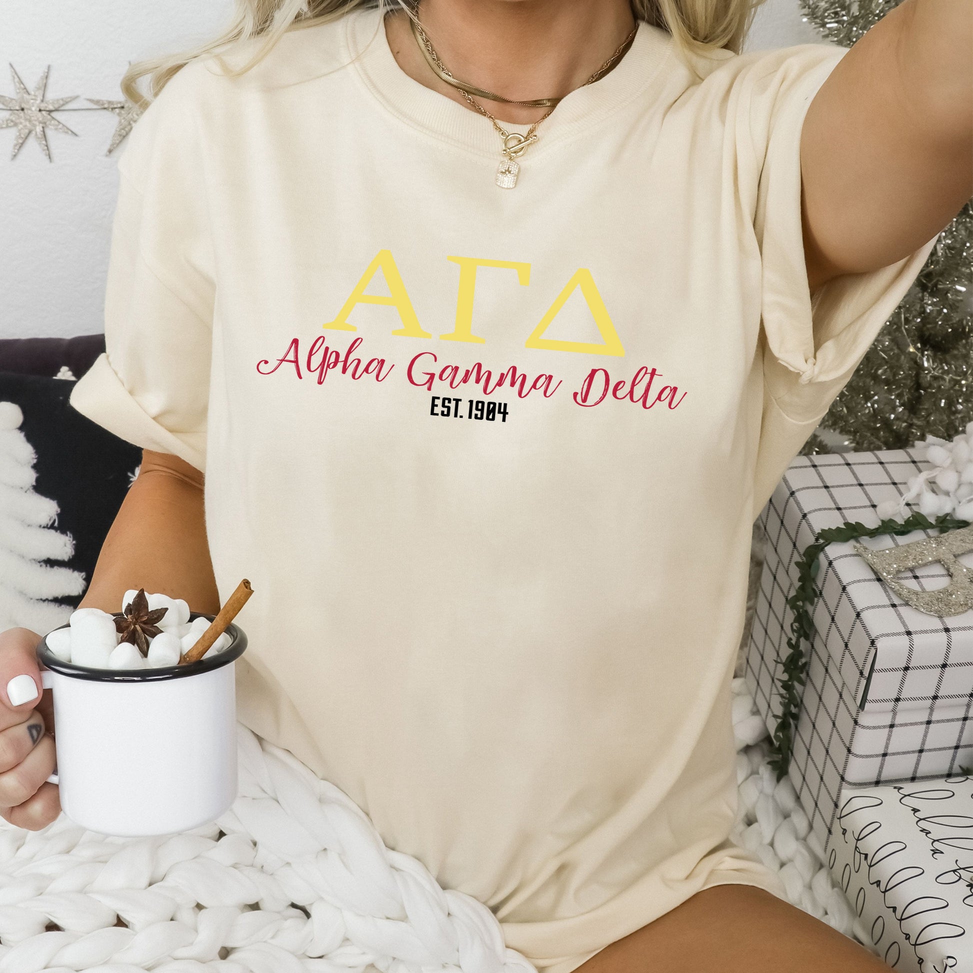 a woman sitting on a bed holding a cup of coffee