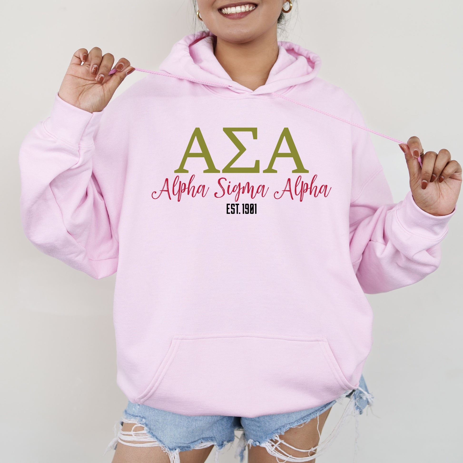 a woman wearing a pink hoodie and ripped shorts